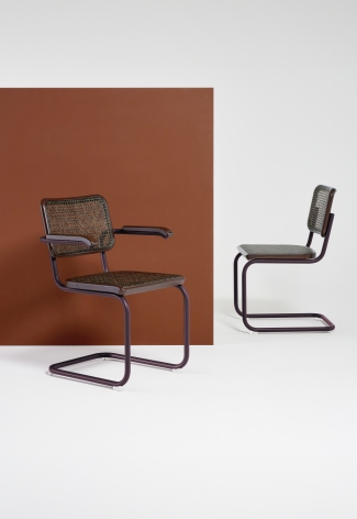 Zwei Thonet S 64 Freischwinger Stühle mit Stahlrohrgestell und Wiener Geflecht vor farbigem Hintergrund.