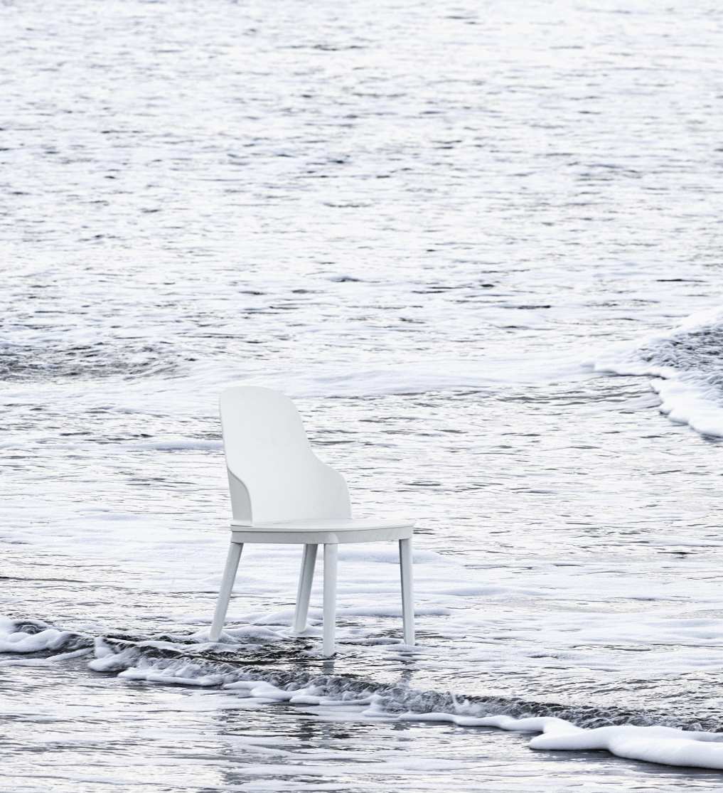 Weißer Allez Chair PP Stuhl von Normann Copenhagen steht im flachen Wasser am Strand.