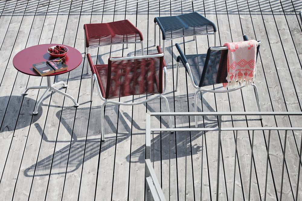 Altorfer Lounge Sessel und Hocker in Rot und Blau auf Holzterrasse. Outdoor Möbel.