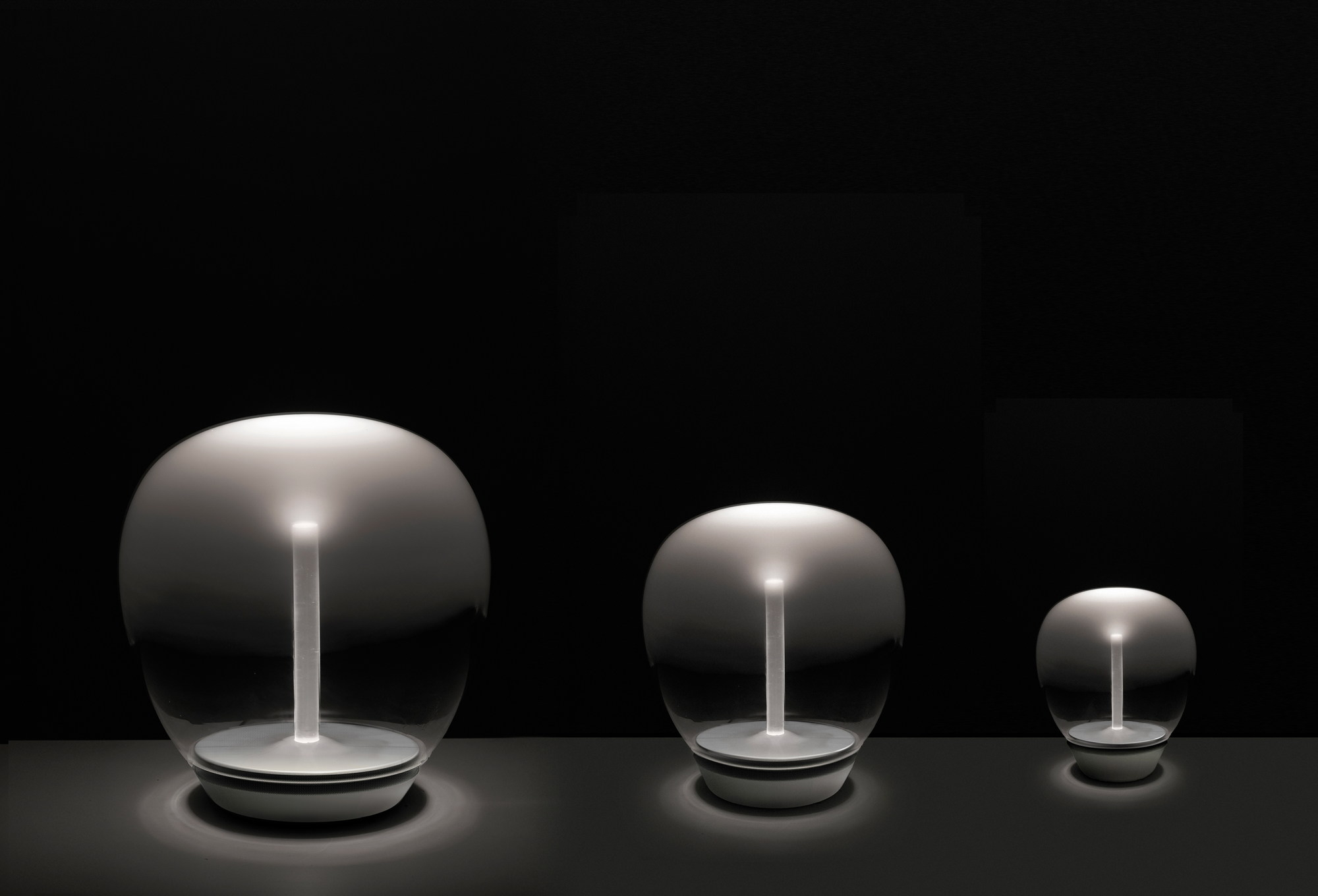 Drei Artemide Empatia Tischleuchten in verschiedenen Größen, modernes Design, stimmungsvolle Beleuchtung.