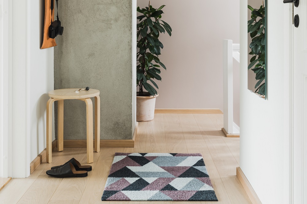 Blåne Heymat Fußmatte Herbst im Flur mit geometrischem Muster in Grau, Rosa und Schwarz.