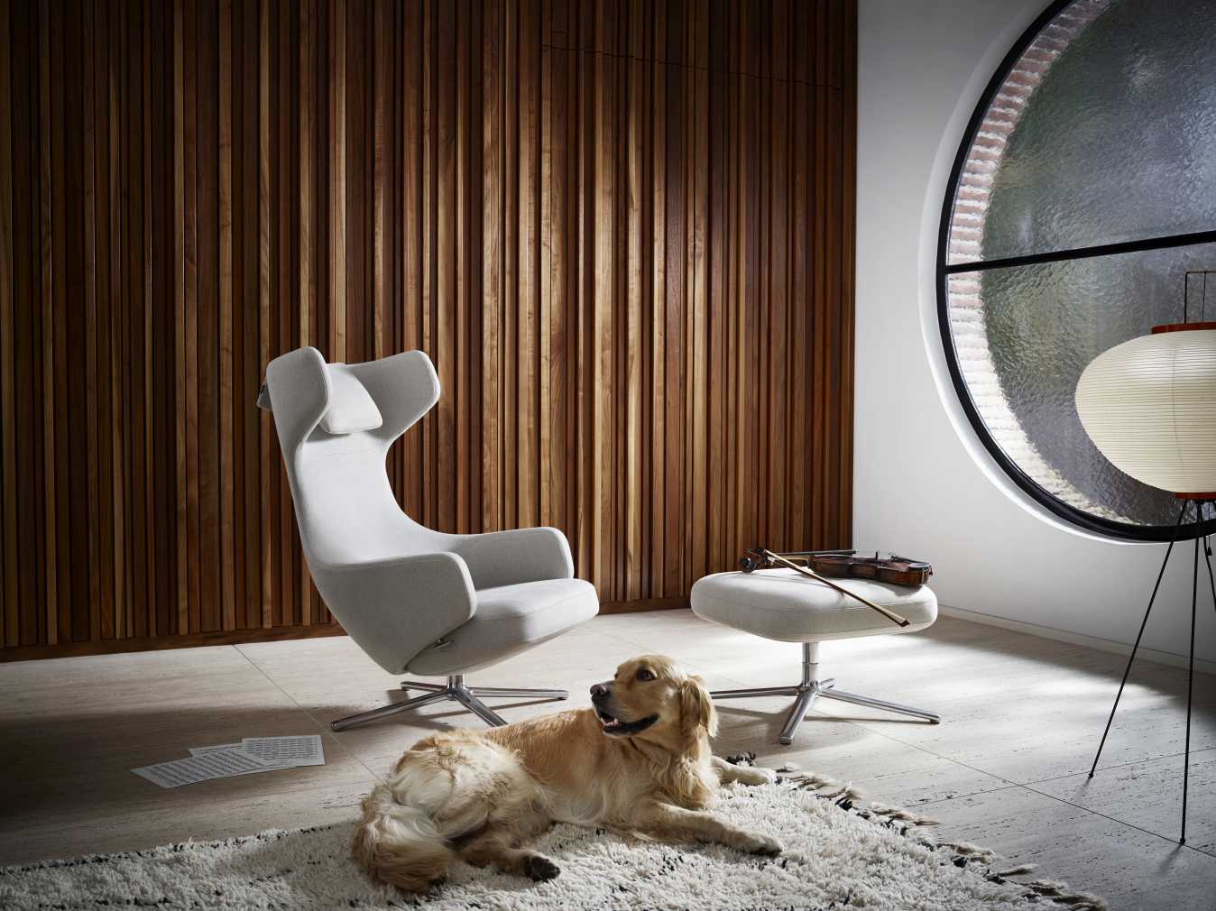 Vitra Grand Repos Sessel mit Ottoman in Rauchblau, Premium Leder und Hund auf Teppich.