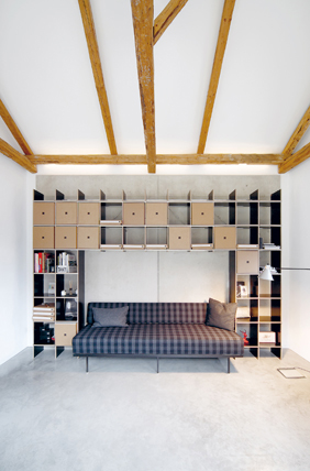 FNP Regal von Nils Holger Moormann in modernem Wohnzimmer mit Sofa und Holzbalken.