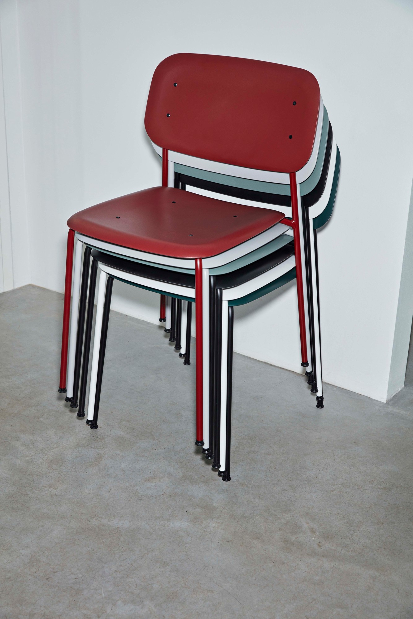 Gestapelte Hay Soft Edge Stühle in Rot, Weiß, Schwarz und Grün. Design Stuhl.