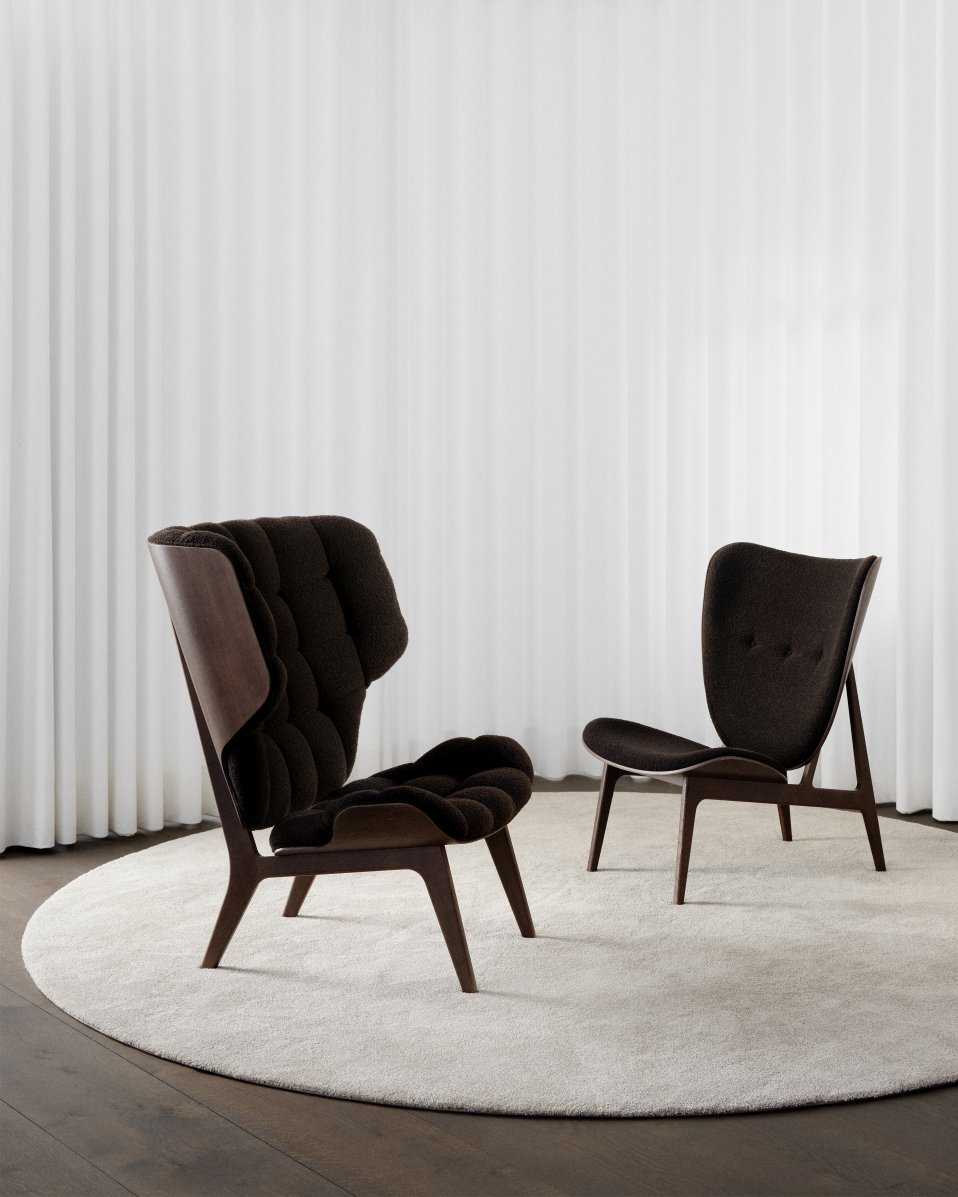 Zwei braune NORR11 Mammoth Chair Sessel aus Holz und Stoff auf einem Teppich.