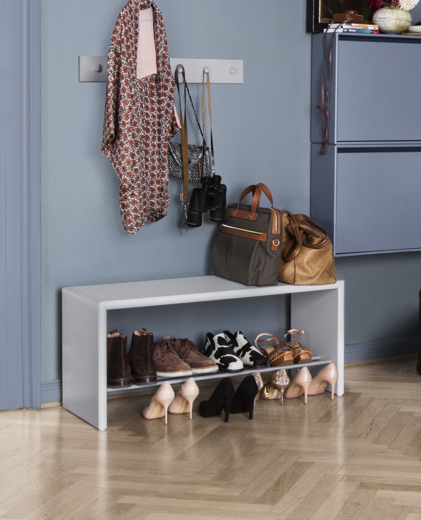Heller Hall Schuhbank mit Schuhen und Taschen im Flur. Schuhaufbewahrung für den Eingangsbereich.