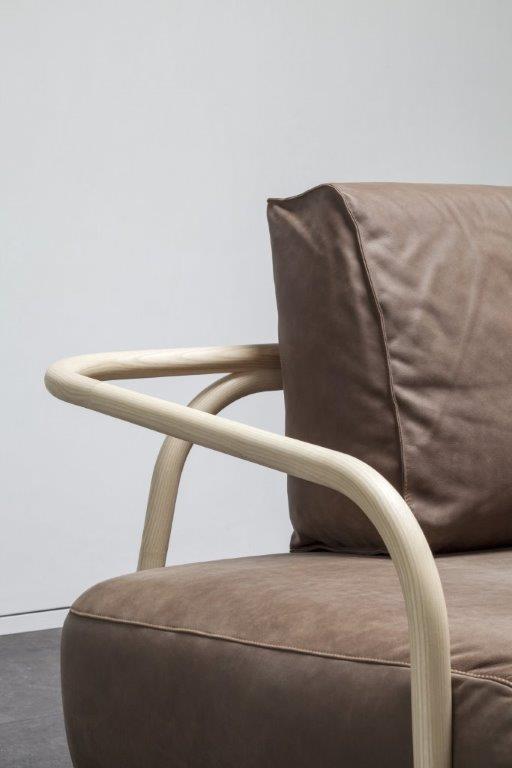 Detailaufnahme des 2002 Bugholz-Sofas von Thonet: Braunes Ledersofa mit hellen Holzarmlehnen, modernes Möbeldesign.