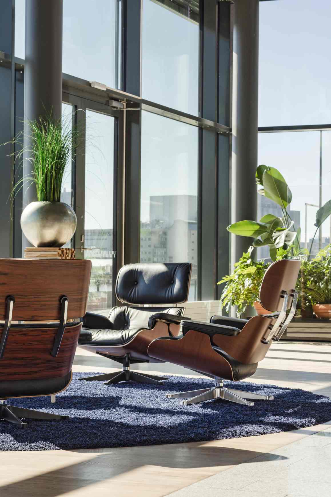 Eames Lounge Chair von Vitra mit Ottoman in schwarzem Leder und dunklem Holz.
