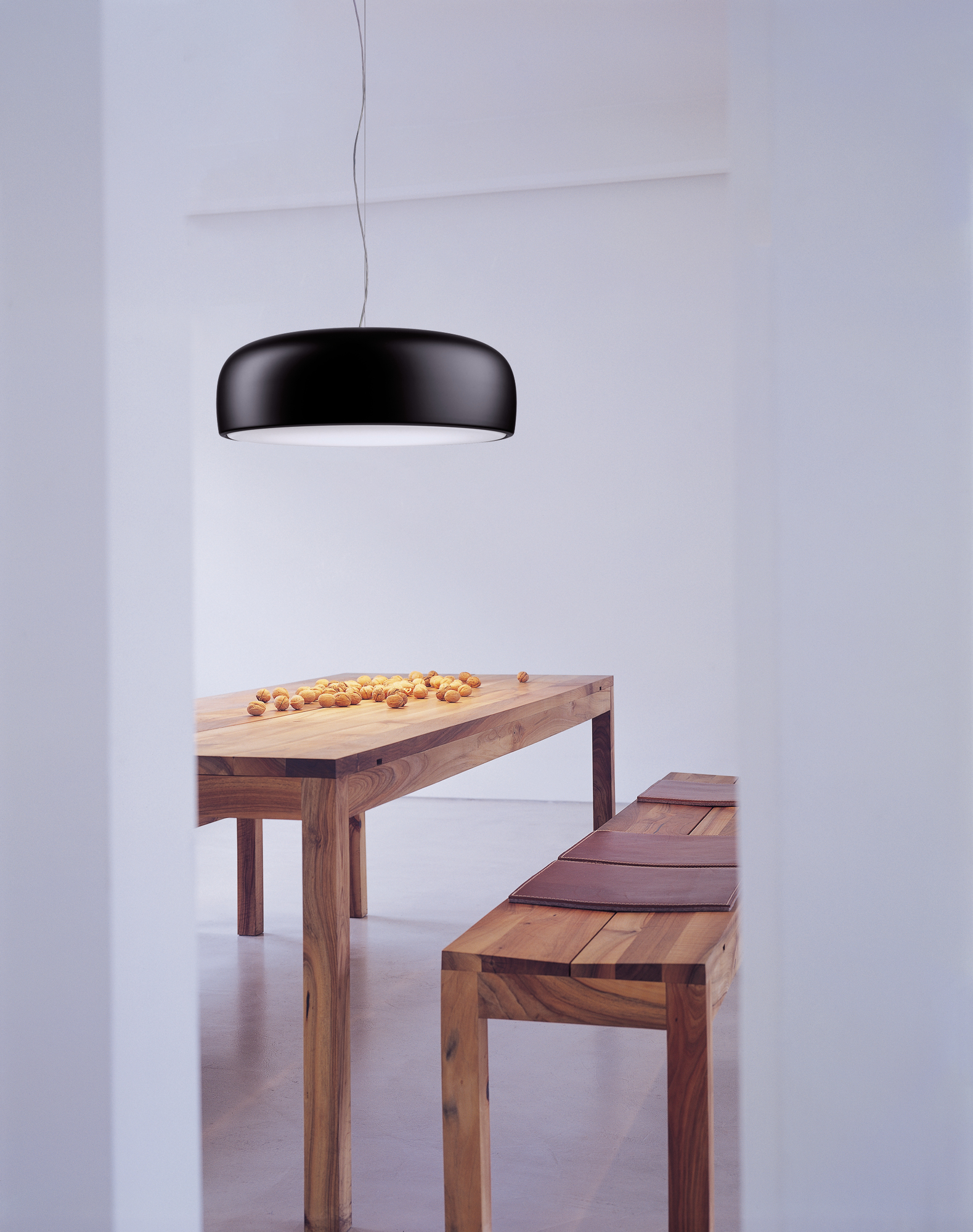 Schwarze Smithfield Pendelleuchte von Flos über Esstisch mit Nüssen, moderne Innenraumbeleuchtung.