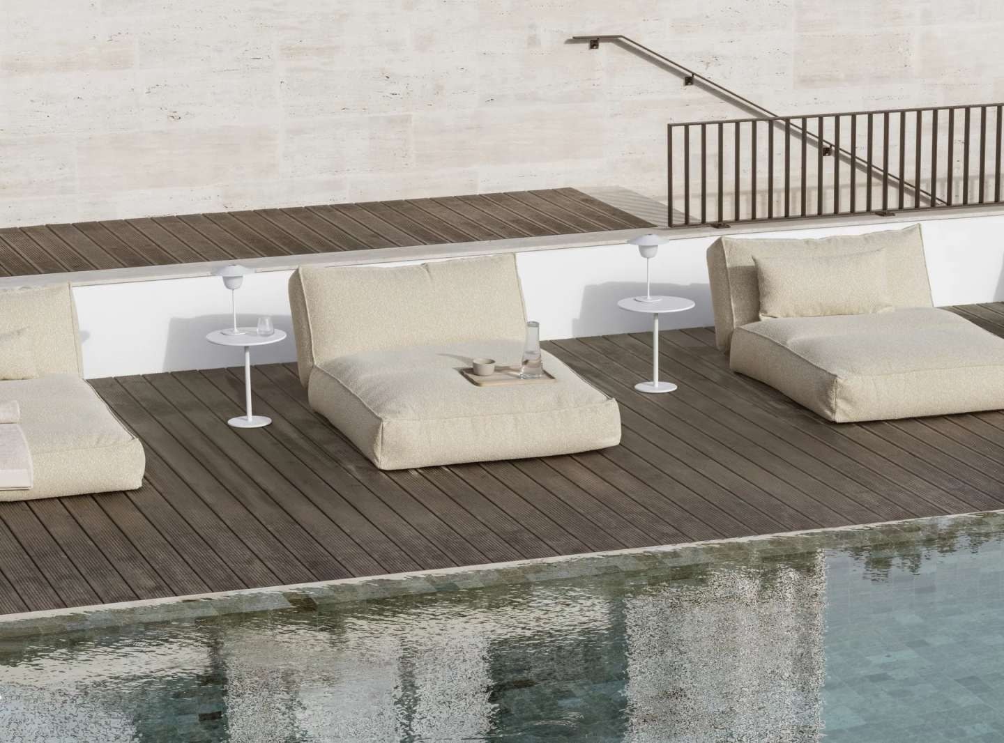 Blomus Reah Sun Outdoor Kissen 80x40 cm neben Pool auf Holzterrasse.