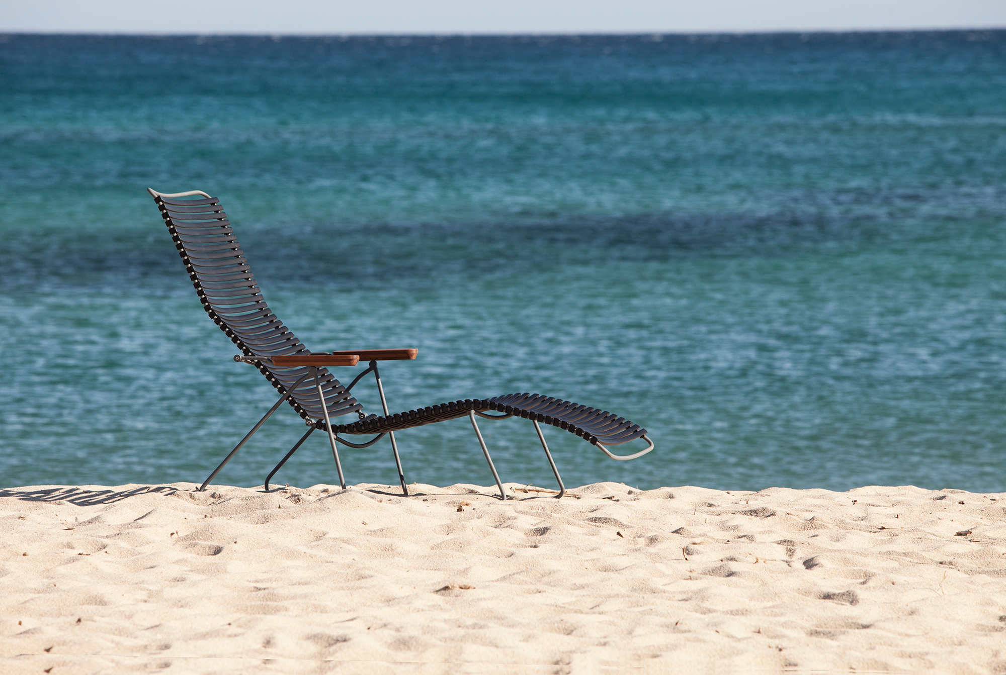 Click Sunlounger: Moderne Outdoor Sonnenliege von Houe am Strand mit Blick auf das Meer.