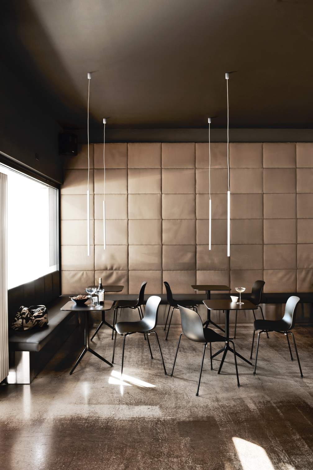 Schwarzer Troy Chair Stuhl mit vier Beinen von Magis in modernem Restaurant-Ambiente.
