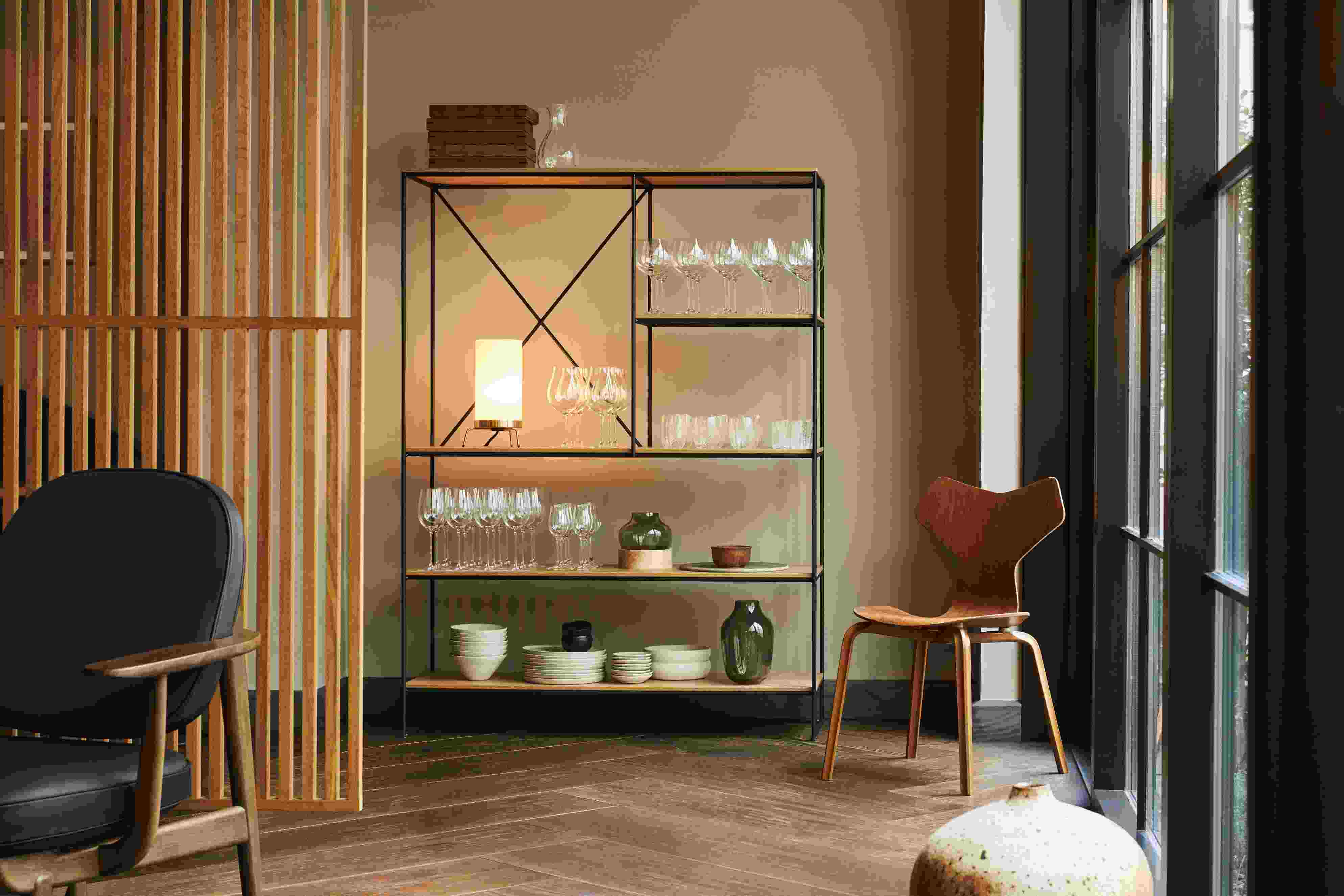 Grand Prix Stuhl von Fritz Hansen aus Holz neben einem Regal mit Geschirr und Gläsern.