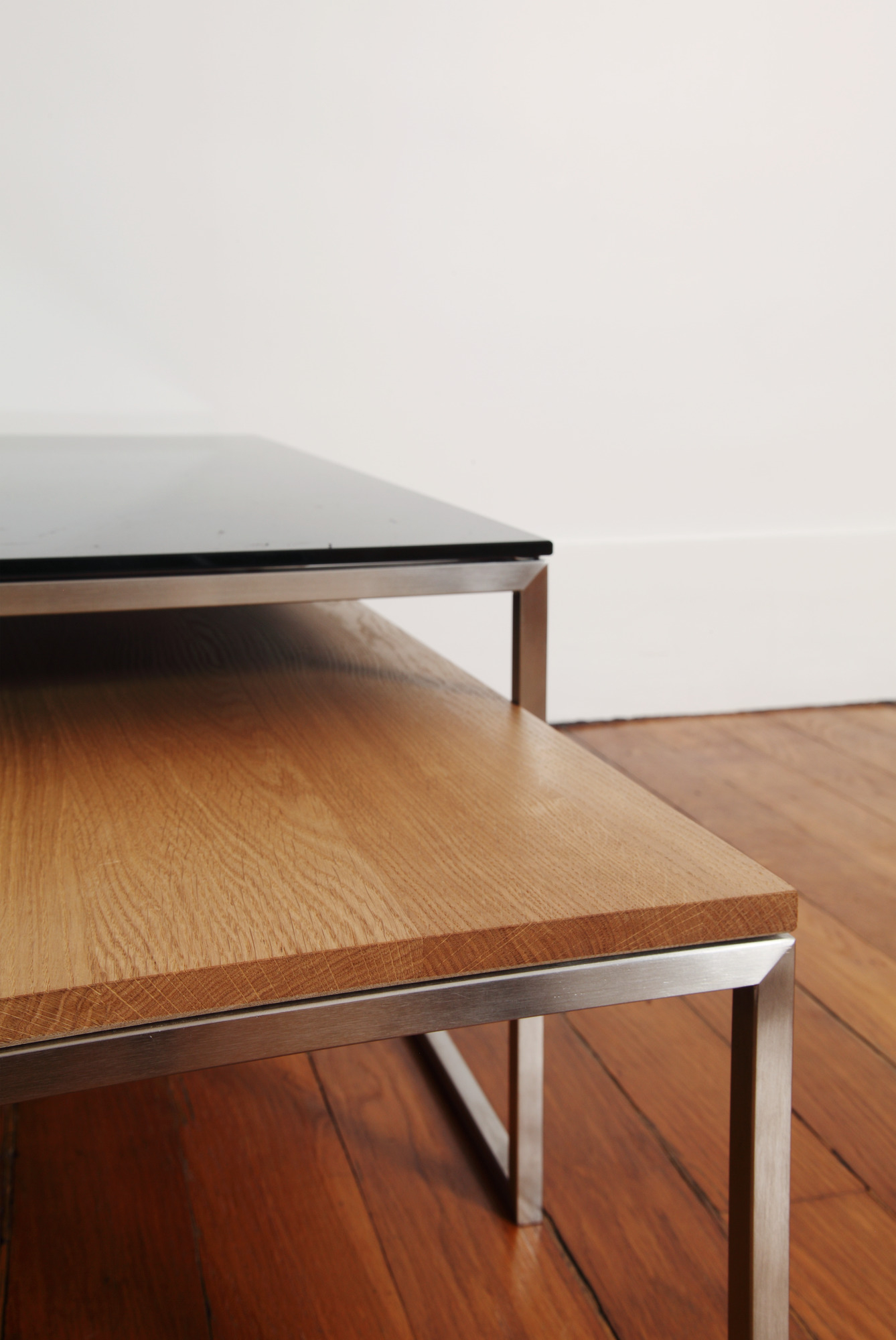 Detailaufnahme: Less H Couchtisch von Hans Hansen mit schwarzer Glasplatte und Holzablage.