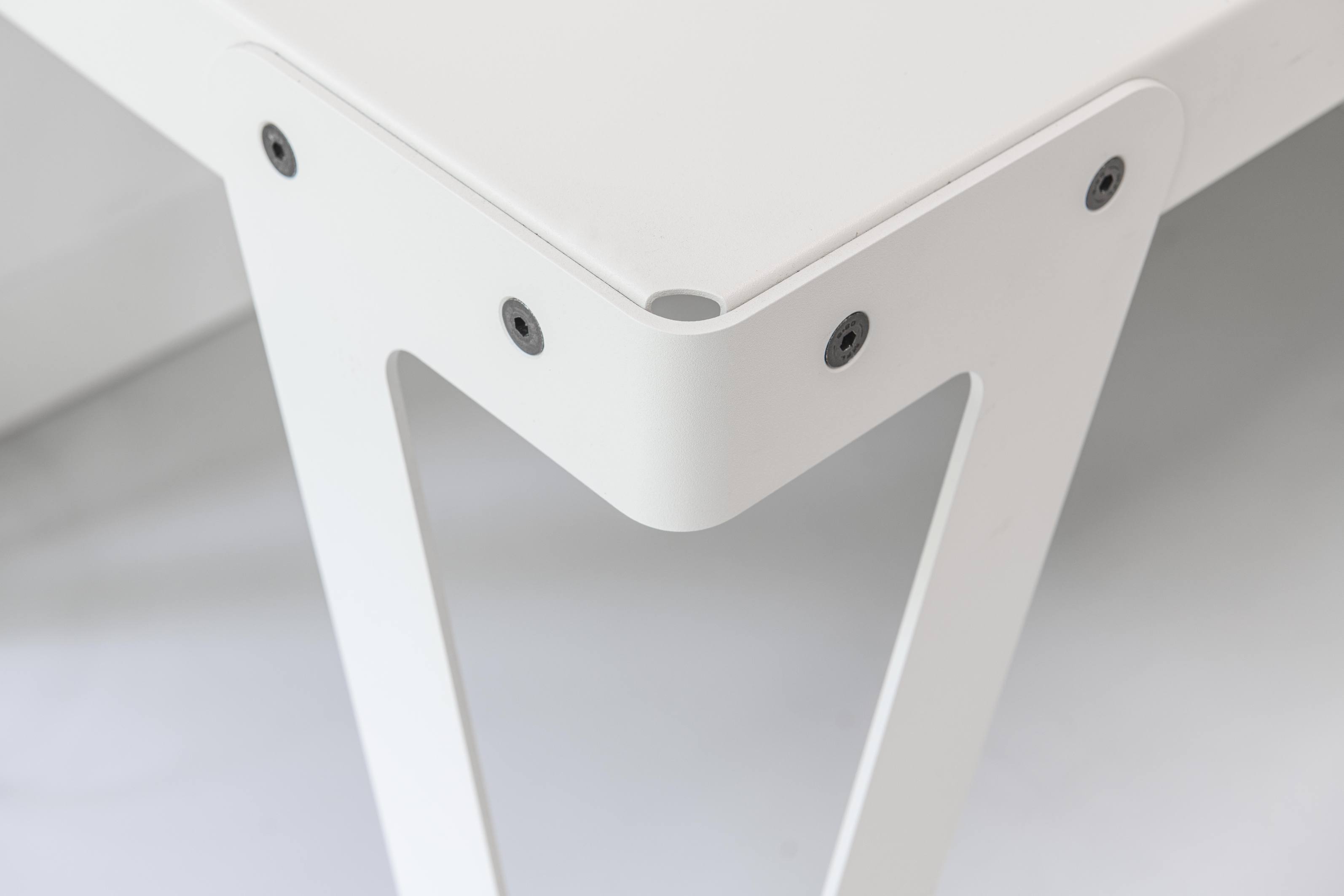 Detailaufnahme des weißen Lloyd Indoor Table Tisches mit Fokus auf Beinbefestigung und minimalistisches Design.