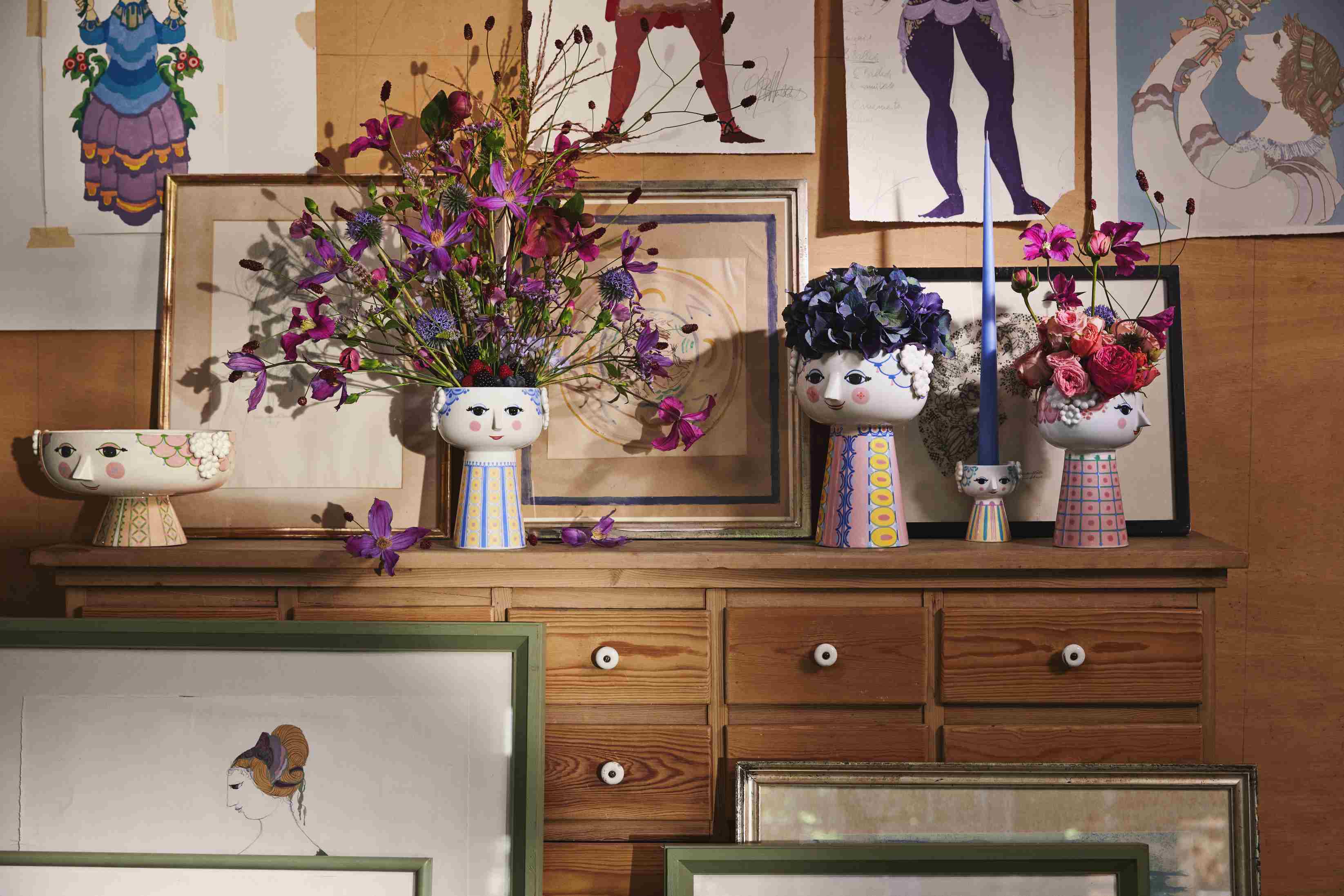 Keramik Vasen mit Gesicht und Blumen auf Kommode, dekorative Wohnaccessoires für stilvolles Interieur.