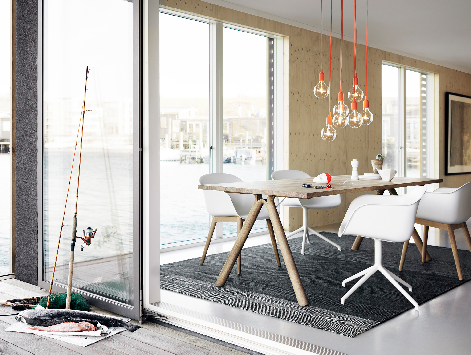 Esszimmer mit Fiber Armchair Stühlen von Muuto, Holztisch und Blick aufs Wasser.