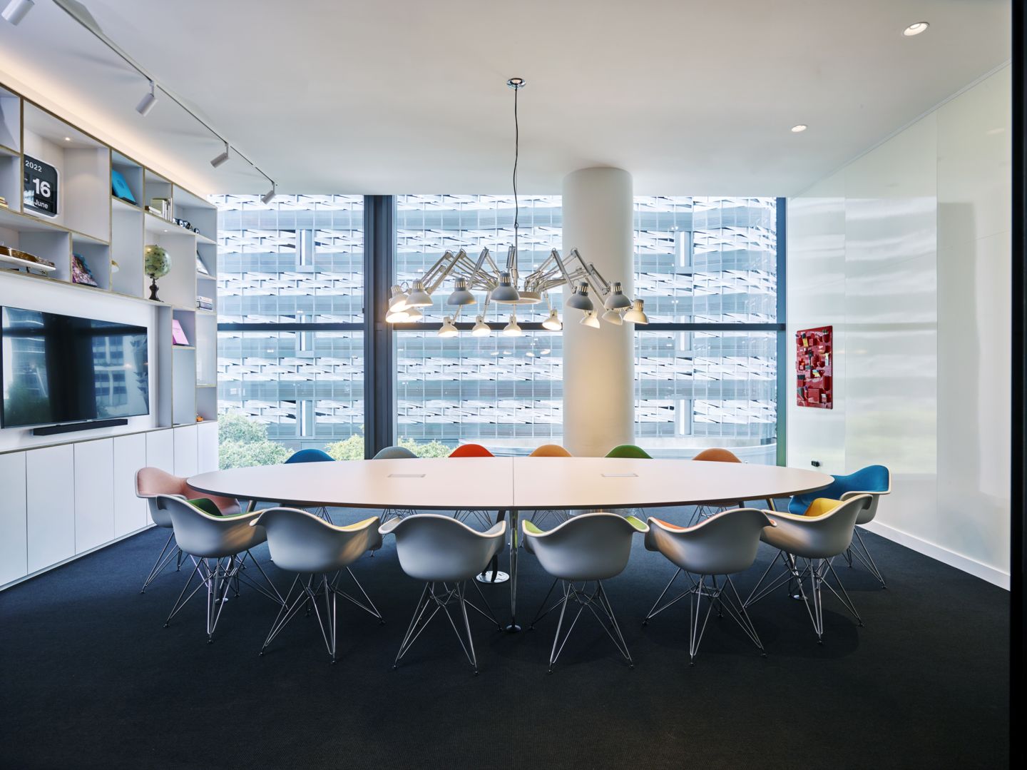 Besprechungsraum mit ovalem Tisch und Eames Plastic Arm Chair DAR Stühlen von Vitra.