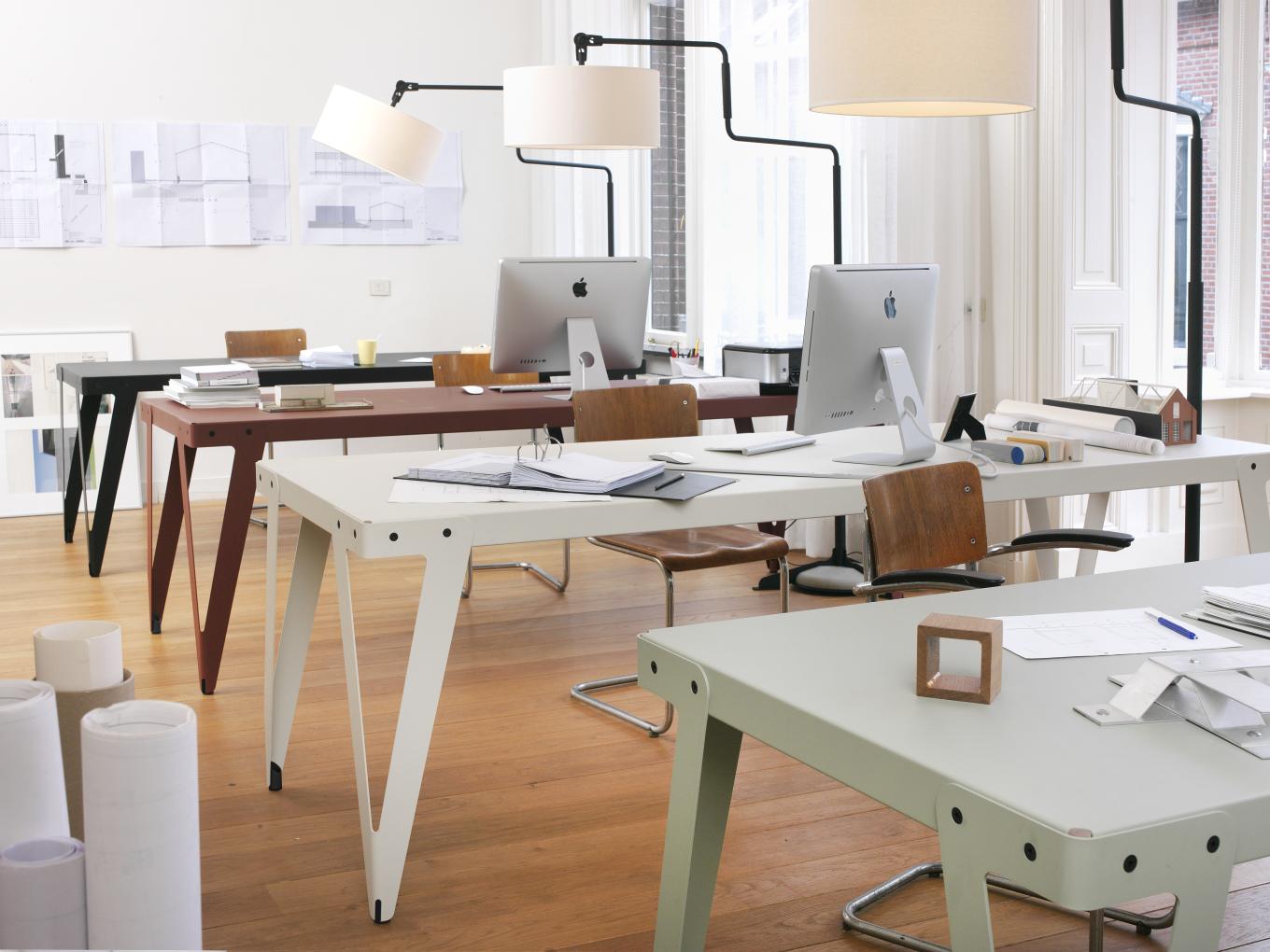 Büro mit mehreren Lloyd Indoor Table Schreibtischen in verschiedenen Farben und passenden Lampen.