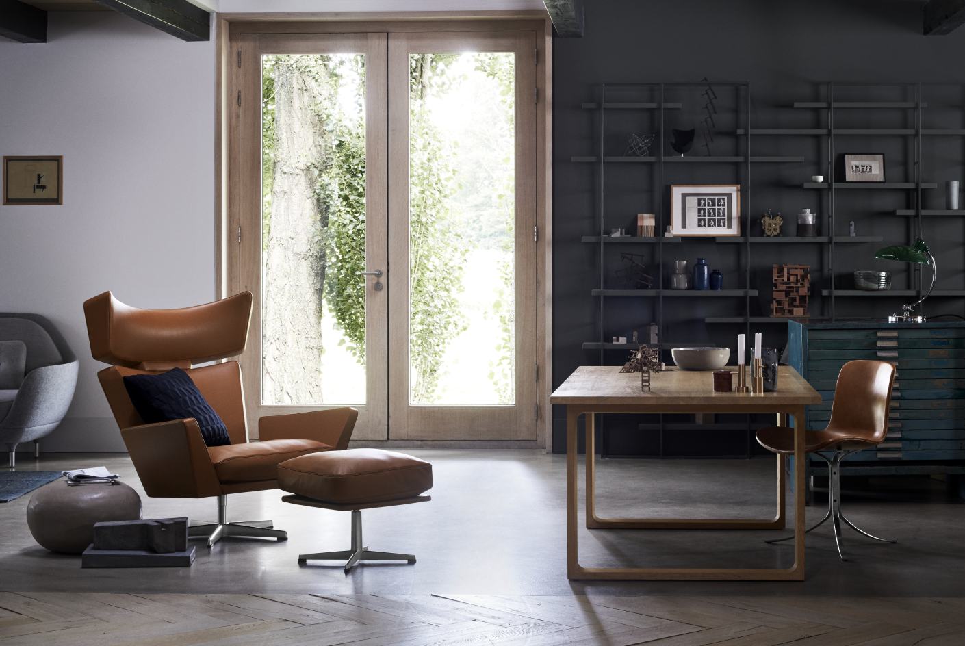 PK9 Sessel von Fritz Hansen in braunem Leder mit Hocker in modernem Wohnzimmer.