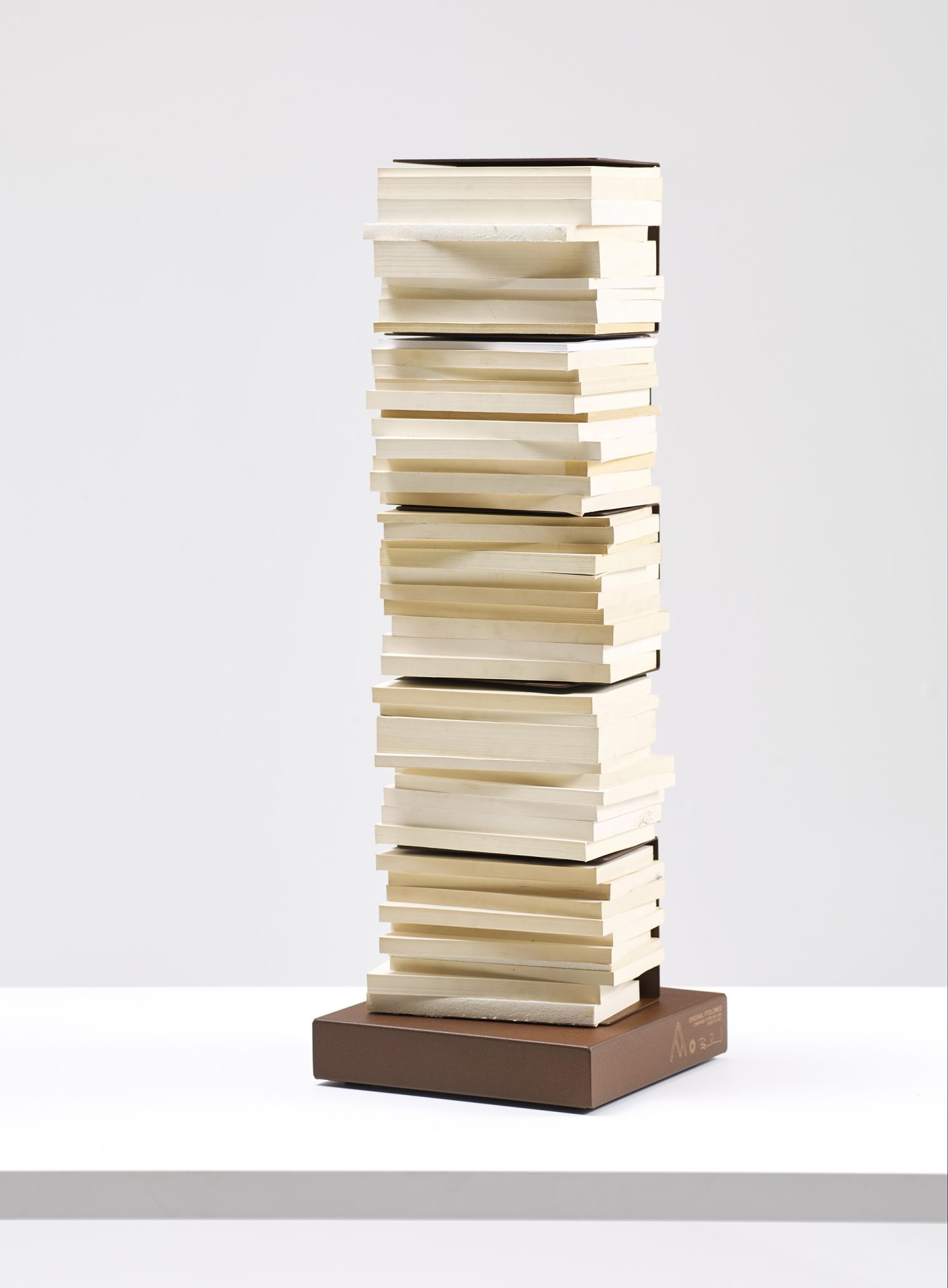 Ptolomeo Bücherregal: Freistehende Design Stele mit vielen Büchern auf einem braunen Sockel.