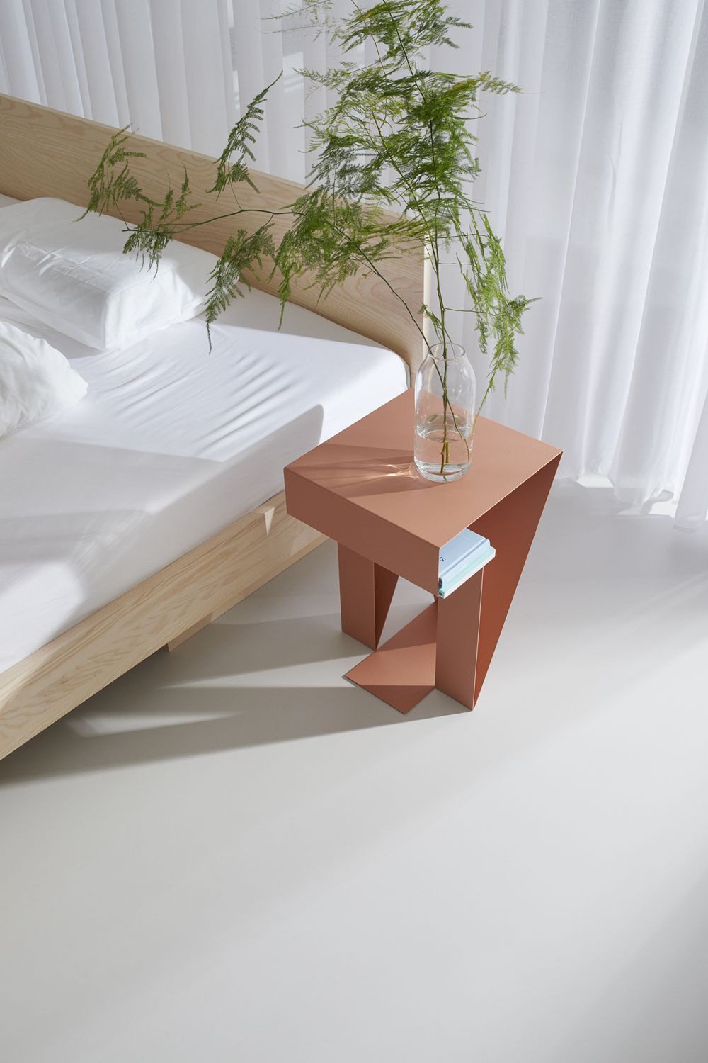 ZIANS Bett Large mit hellem Holzrahmen und Nachttisch in Terrakotta mit Dekoration vor Vorhang.