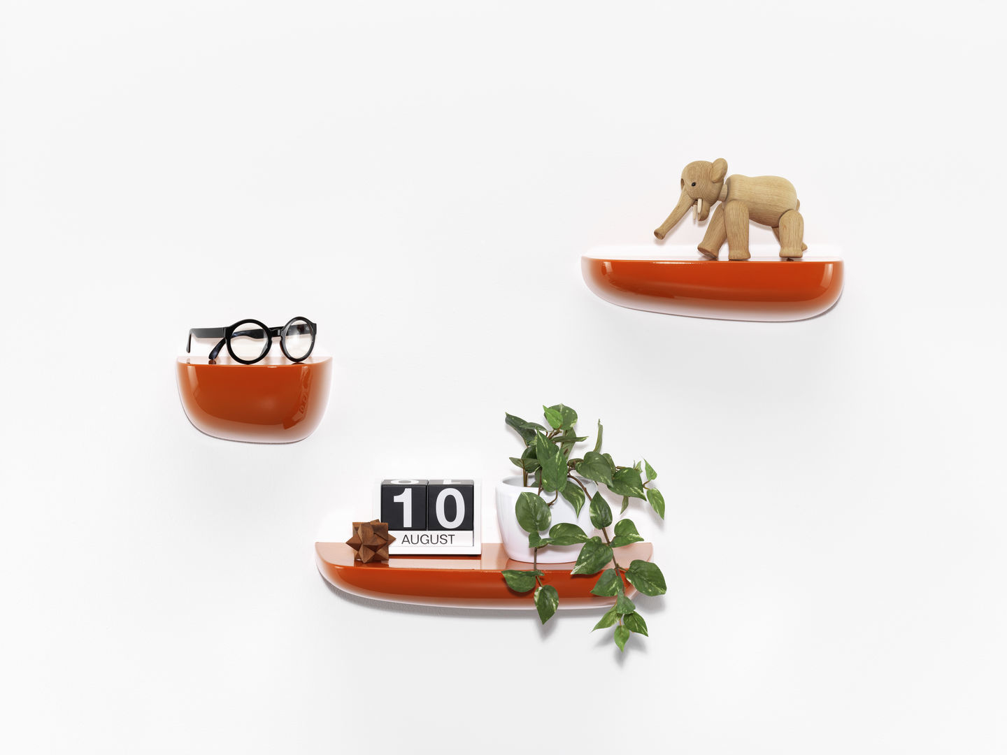 Orangefarbene Vitra Corniches Wandboards in verschiedenen Größen an einer weißen Wand mit Dekoration.