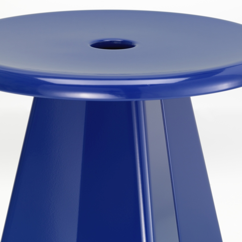 Detailaufnahme des blauen Vitra Tabouret Métallique Hockers mit runder Sitzfläche und konischem Fuß.