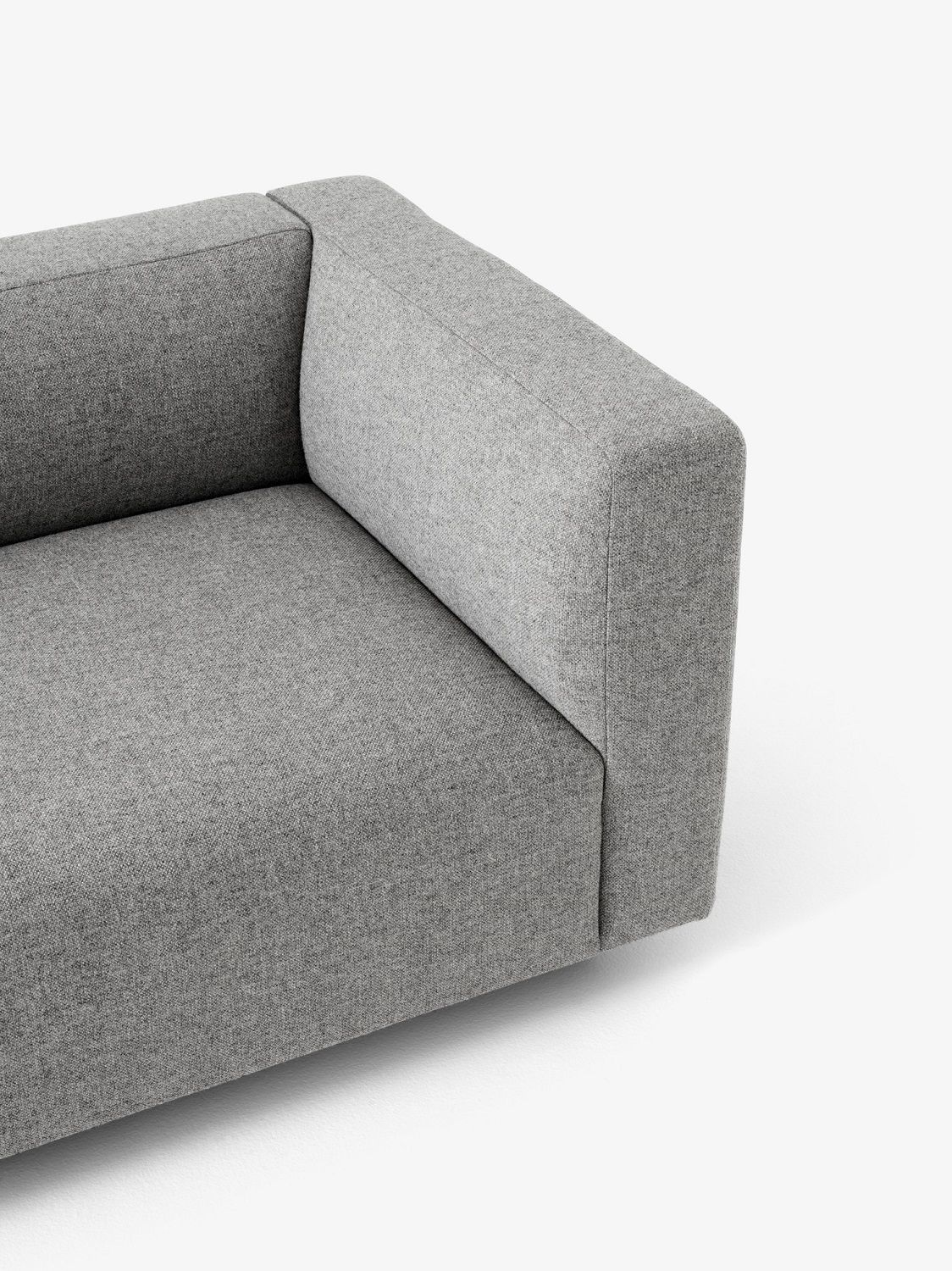 Detailaufnahme des grauen Develius Sofas von AndTradition mit Armlehne und hochwertigem Stoffbezug.
