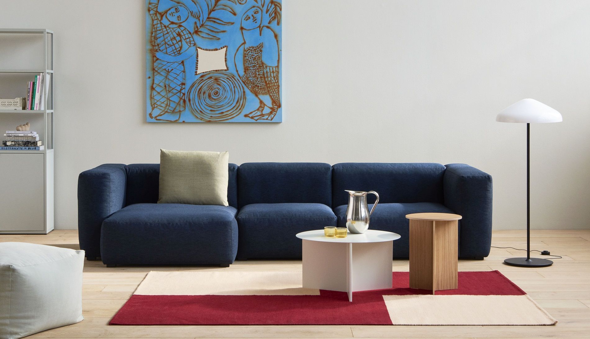 Heller Wohnraum mit blauem Sofa, Hay Slit Table Wood Round Beistelltisch aus Eiche und Designelementen.