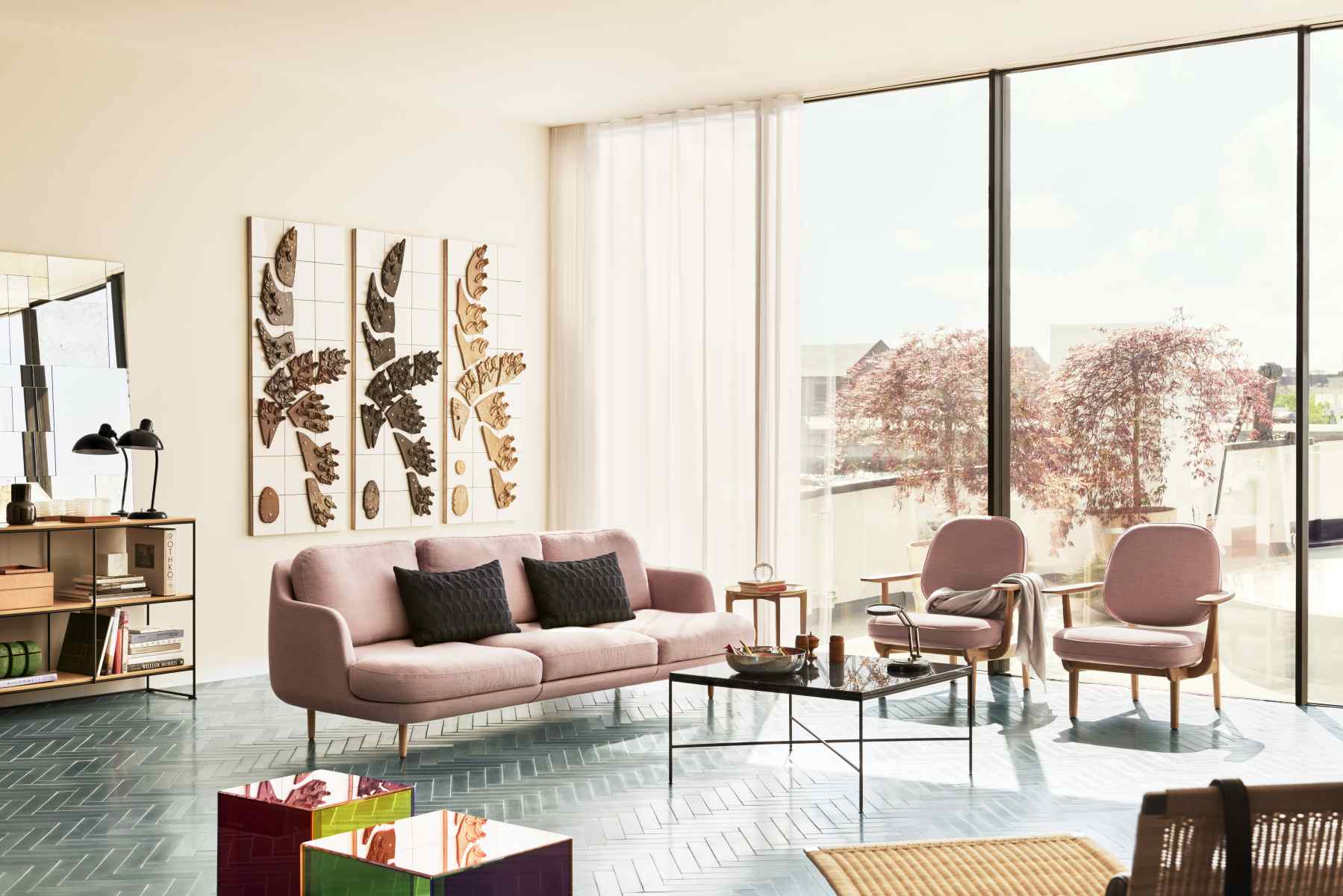 Rosa Fred Loungesessel von Fritz Hansen in modernem Wohnzimmer mit Sofa, Tisch und Kunst.