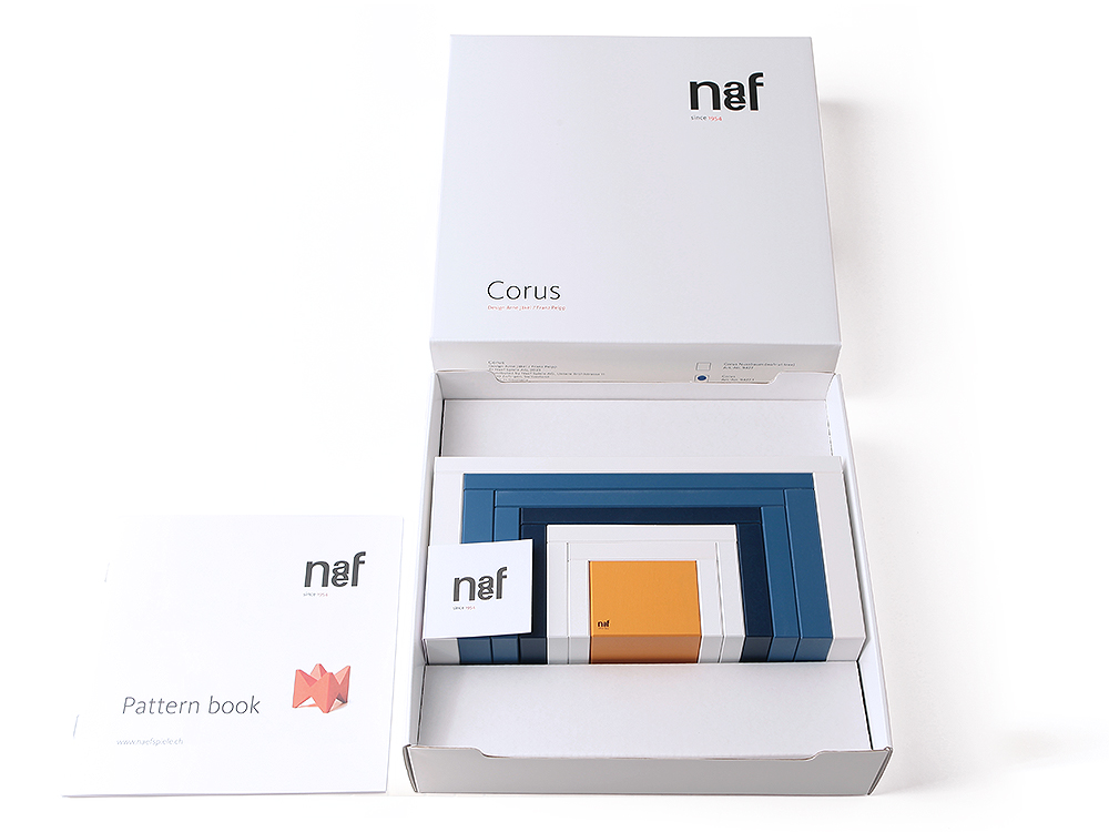 Naef Corus Steckspiel in geöffneter Verpackung mit Musterbuch, hochwertiges Holzspielzeug für Kinder und Erwachsene.