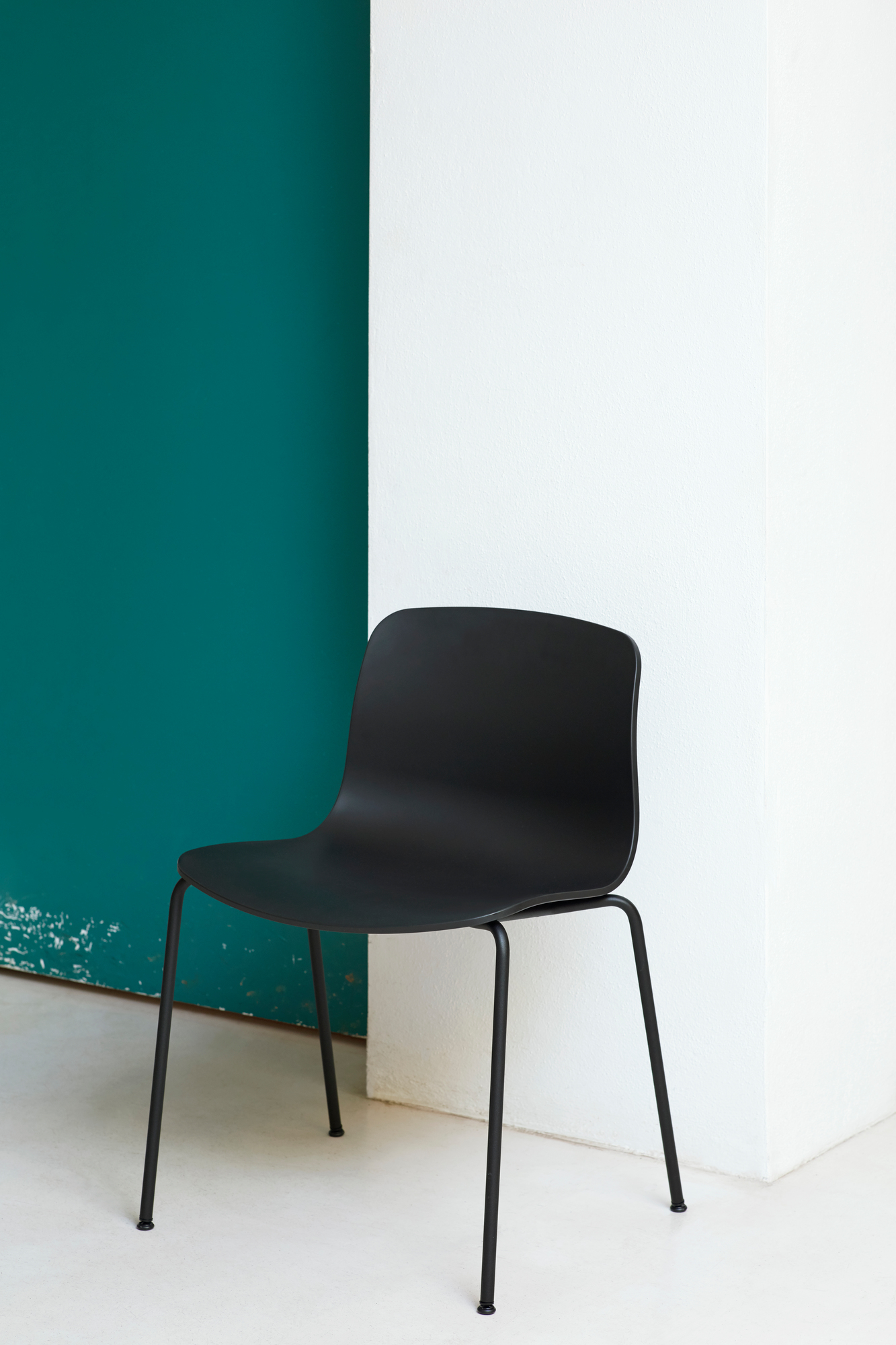 Schwarzer About a Chair AAC16 Stuhl von Hay vor einer Wand in Weiß und Petrol.