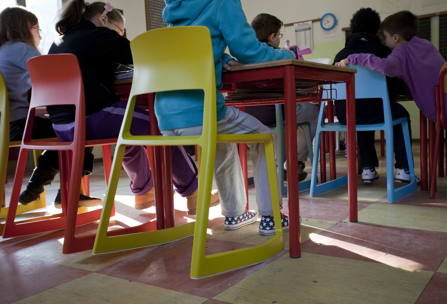 Bunte Tip Ton Stühle von Vitra in einem Klassenzimmer mit Schülern an roten Tischen.