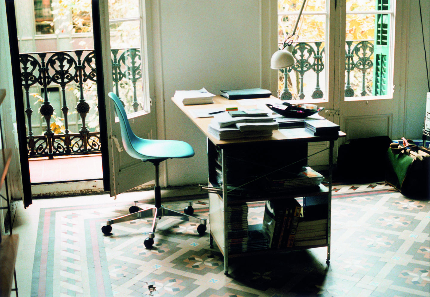 Büro mit blauem Eames Plastic Side Chair Drehstuhl von Vitra am Schreibtisch.