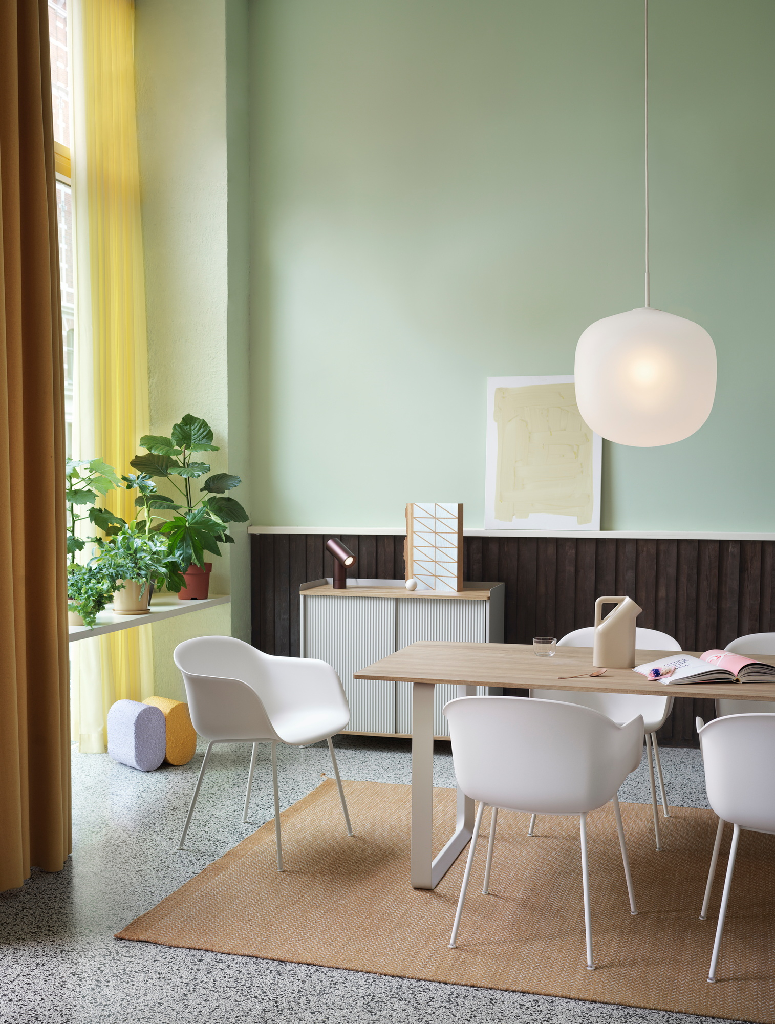 Helle, graue Rime Pendelleuchte von Muuto über einem Esstisch in einem modernen Esszimmer.