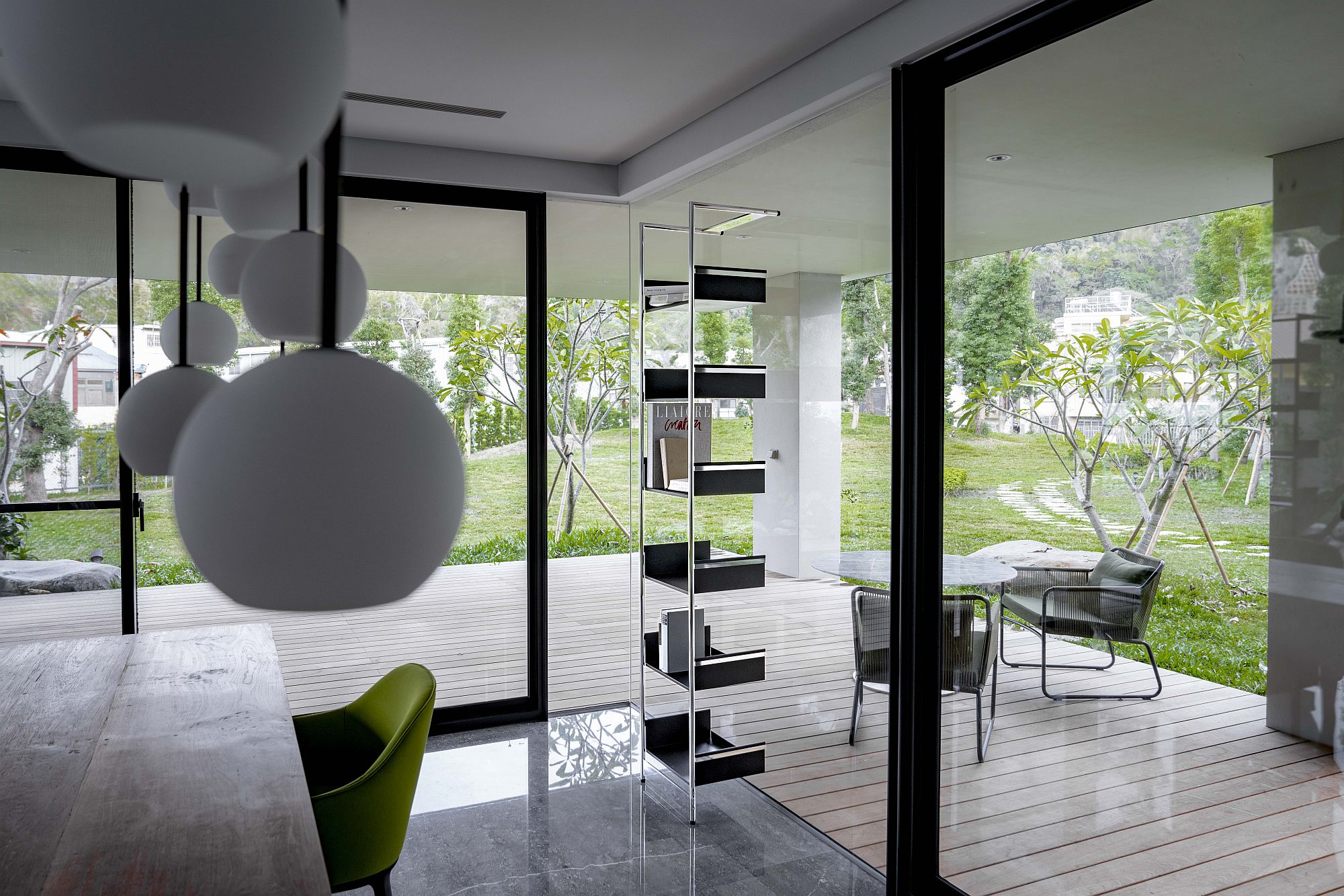 Modernes Wohnzimmer mit Pool 220 Anlehnregal von Mox, minimalistisches Design, offene Gestaltung und Blick in den Garten.