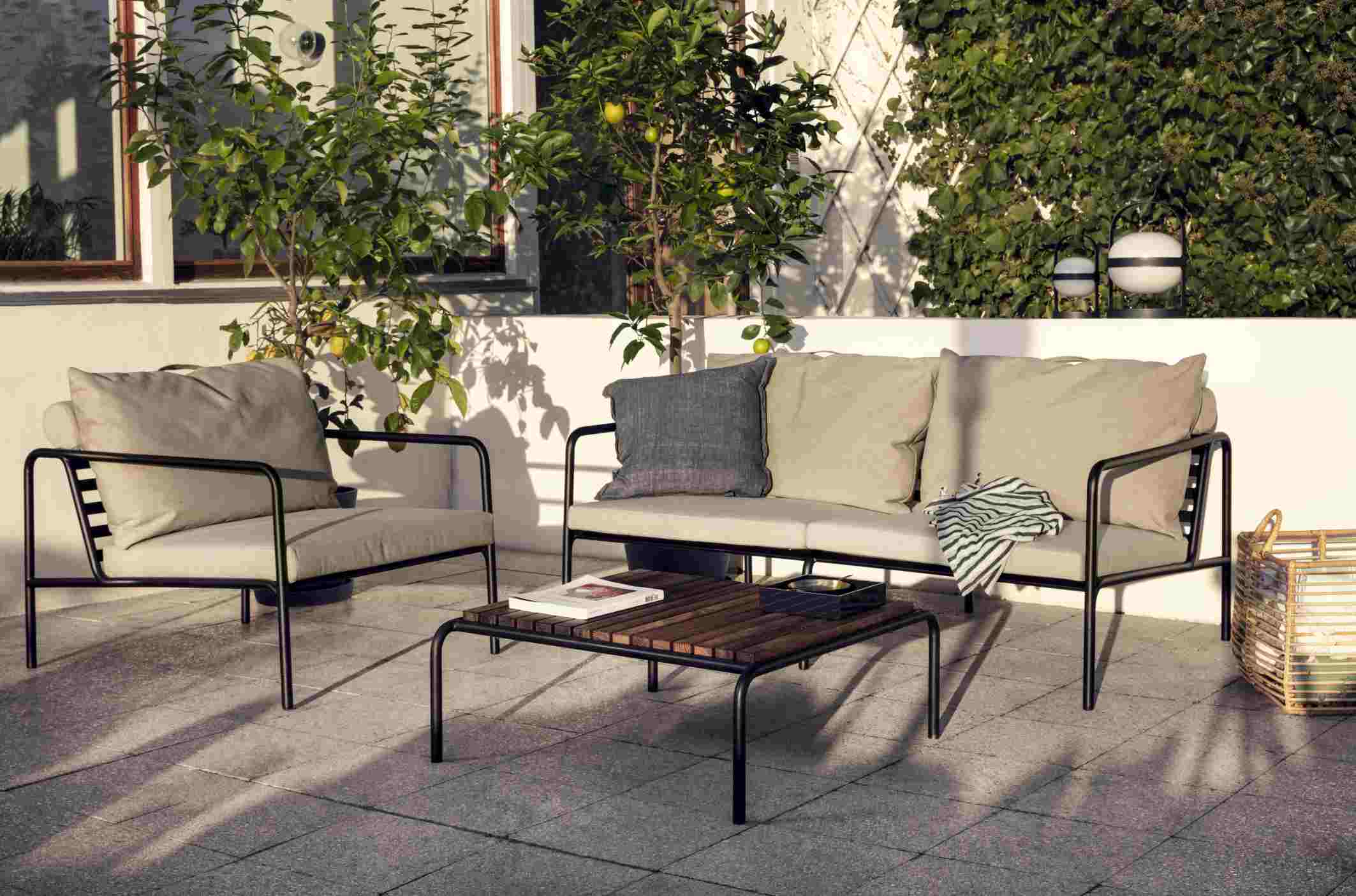 Avon Lounge Table: Outdoor-Sitzgruppe mit Tisch und bequemen Polstern auf einer Terrasse.
