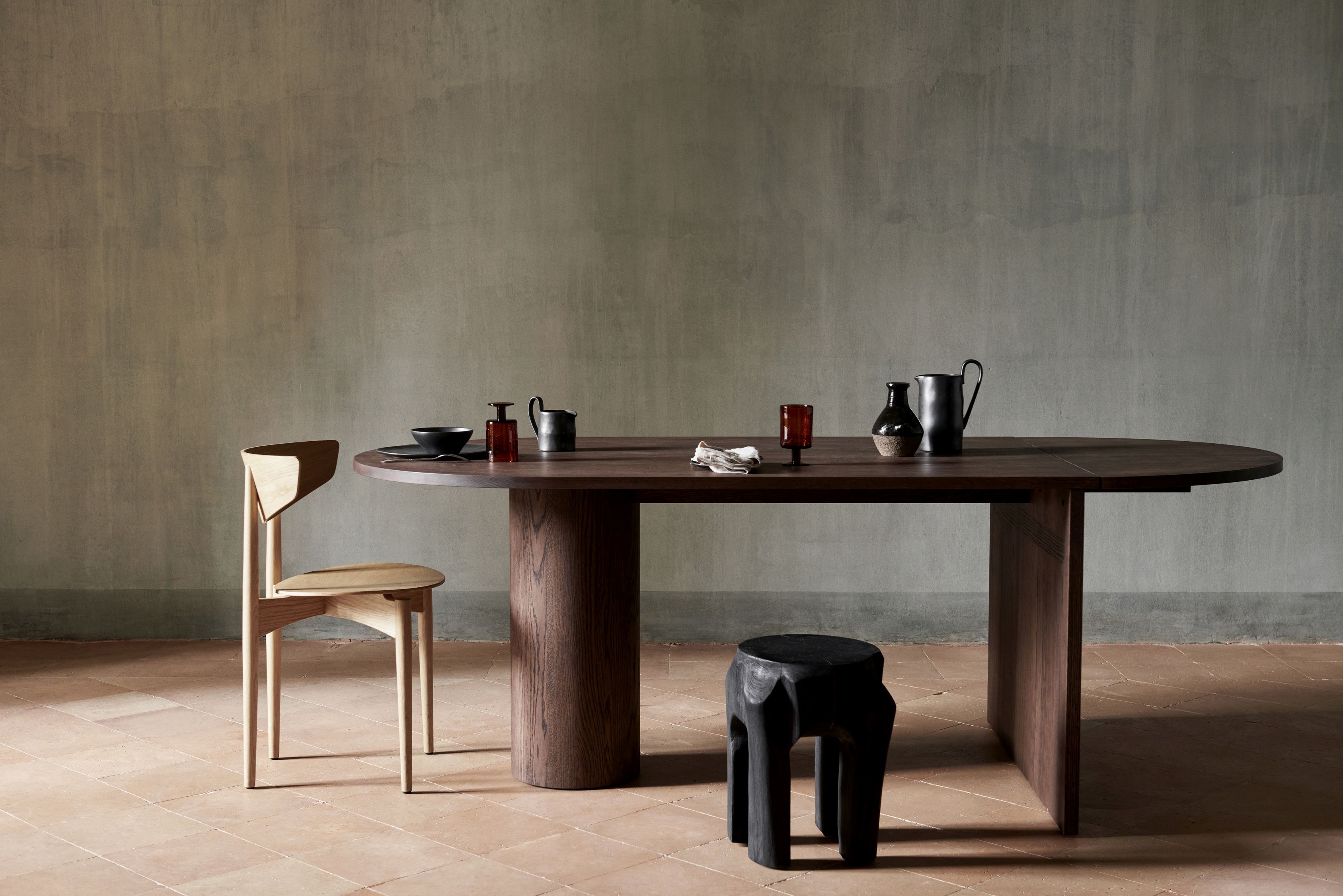 Pylo Esstisch von Ferm Living aus dunkel gebeizter Eiche mit Stuhl und Dekoration.
