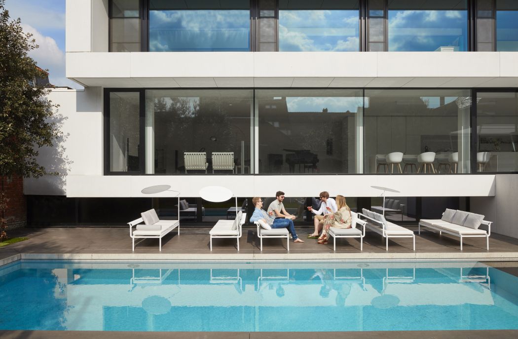 Sol + Luna Sonnenliege von Extremis am Pool, vier Personen sitzen und entspannen im Freien.