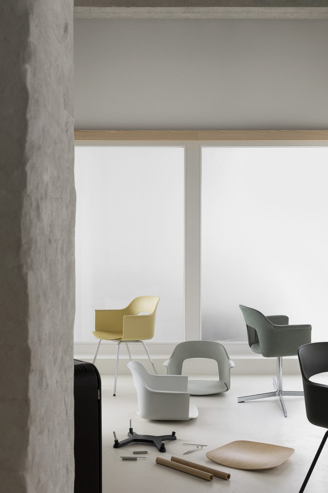 Gelber Hay Armlehnstuhl "Layout Armchair 212" mit Armlehnen und weitere moderne Design-Stühle im Raum.
