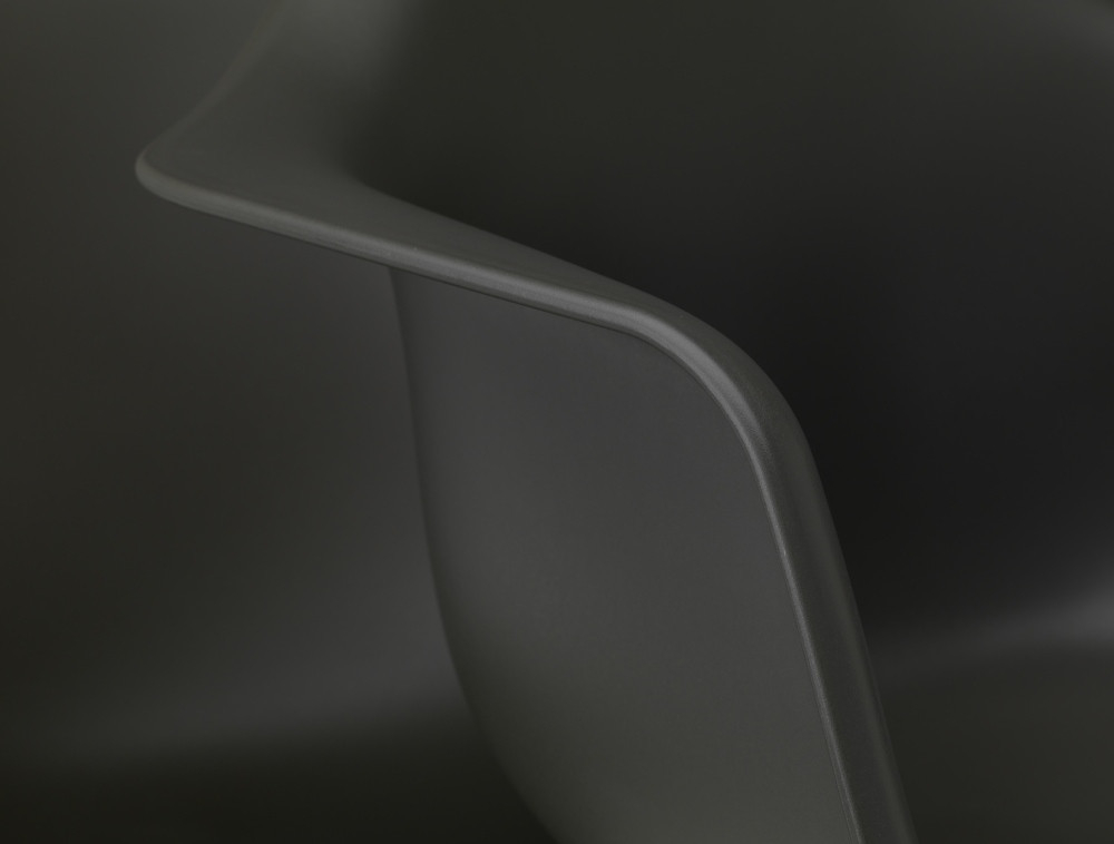 Detailaufnahme der Armlehne eines grauen Eames Plastic Arm Chair PACC Stuhls von Vitra.
