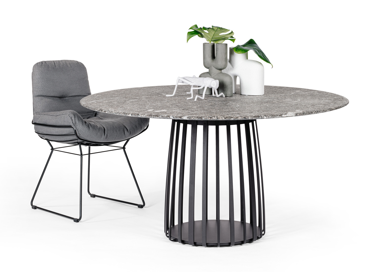 BC 07 Basket Outdoor Tisch von Janua mit Stuhl, runde Tischplatte und schwarzem Metallgestell.