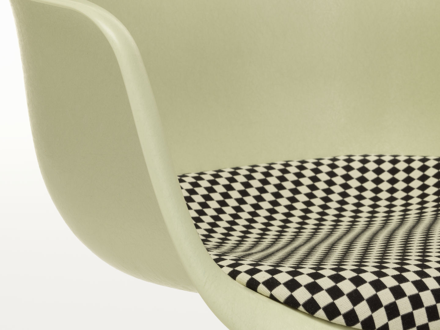 Detailaufnahme von Vitra Eames Plastic Arm Chair DAL in Hellgrün mit Schachbrettmuster-Sitzpolster.