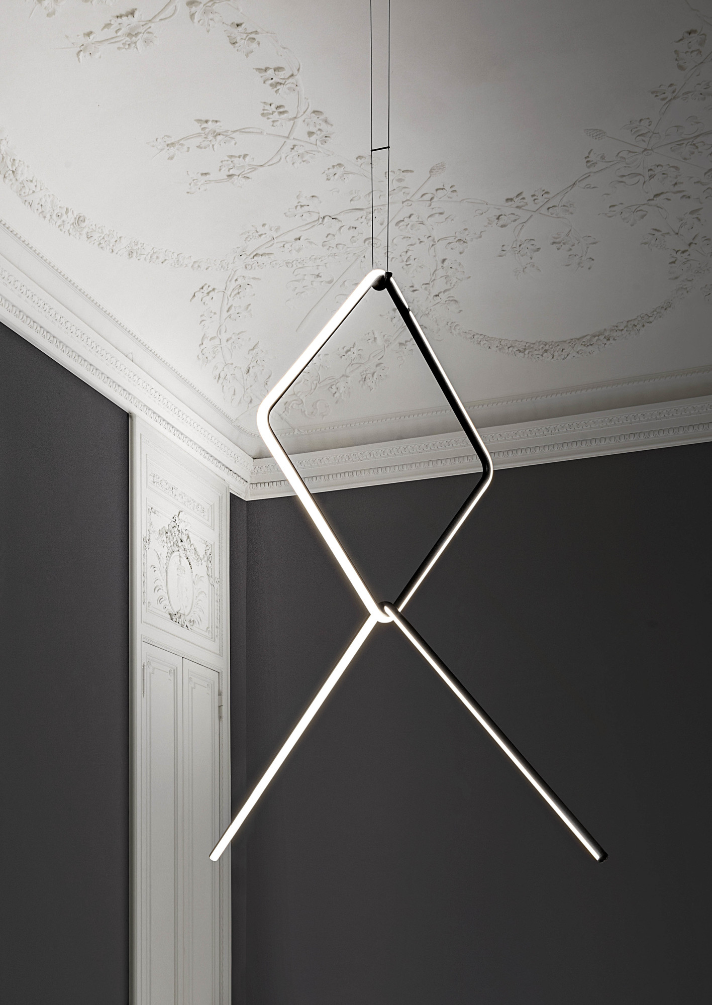 Flos Arrangements Pendelleuchte mit geometrischem Design aus leuchtenden Linien, die von der Decke hängen.