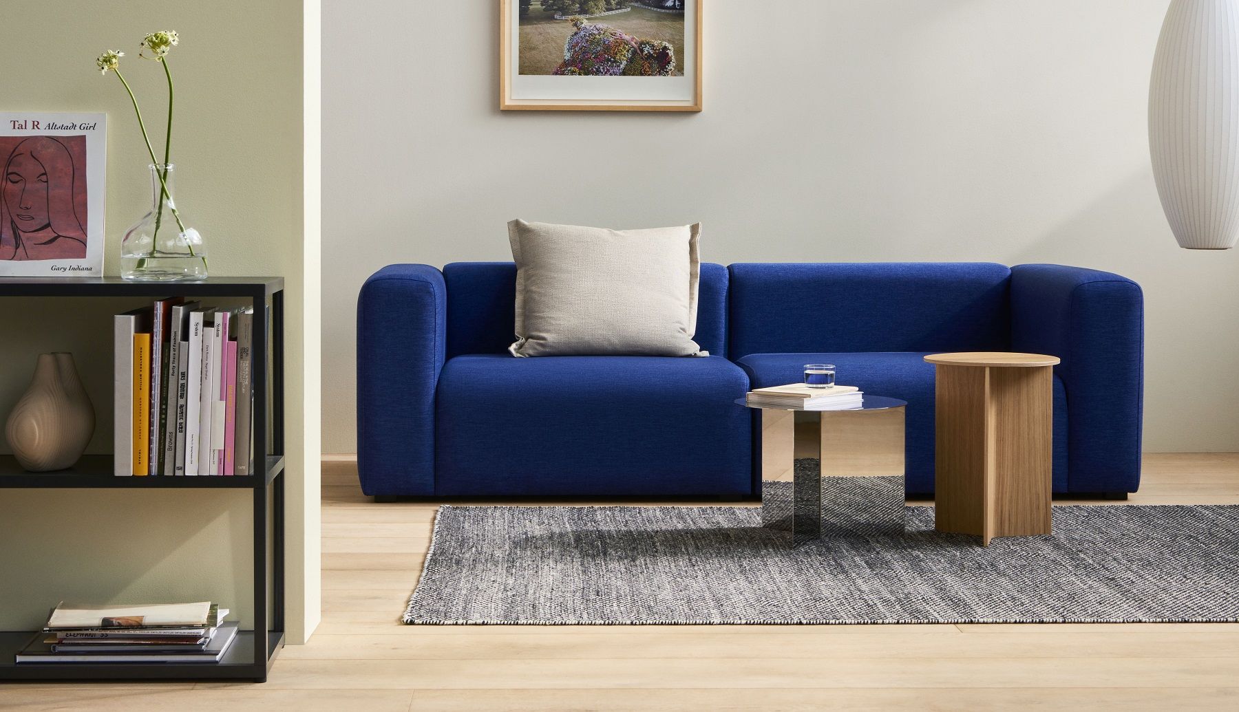 Hay Slit Table Wood Round High Beistelltisch aus Eiche neben blauem Sofa und silbernem Couchtisch.