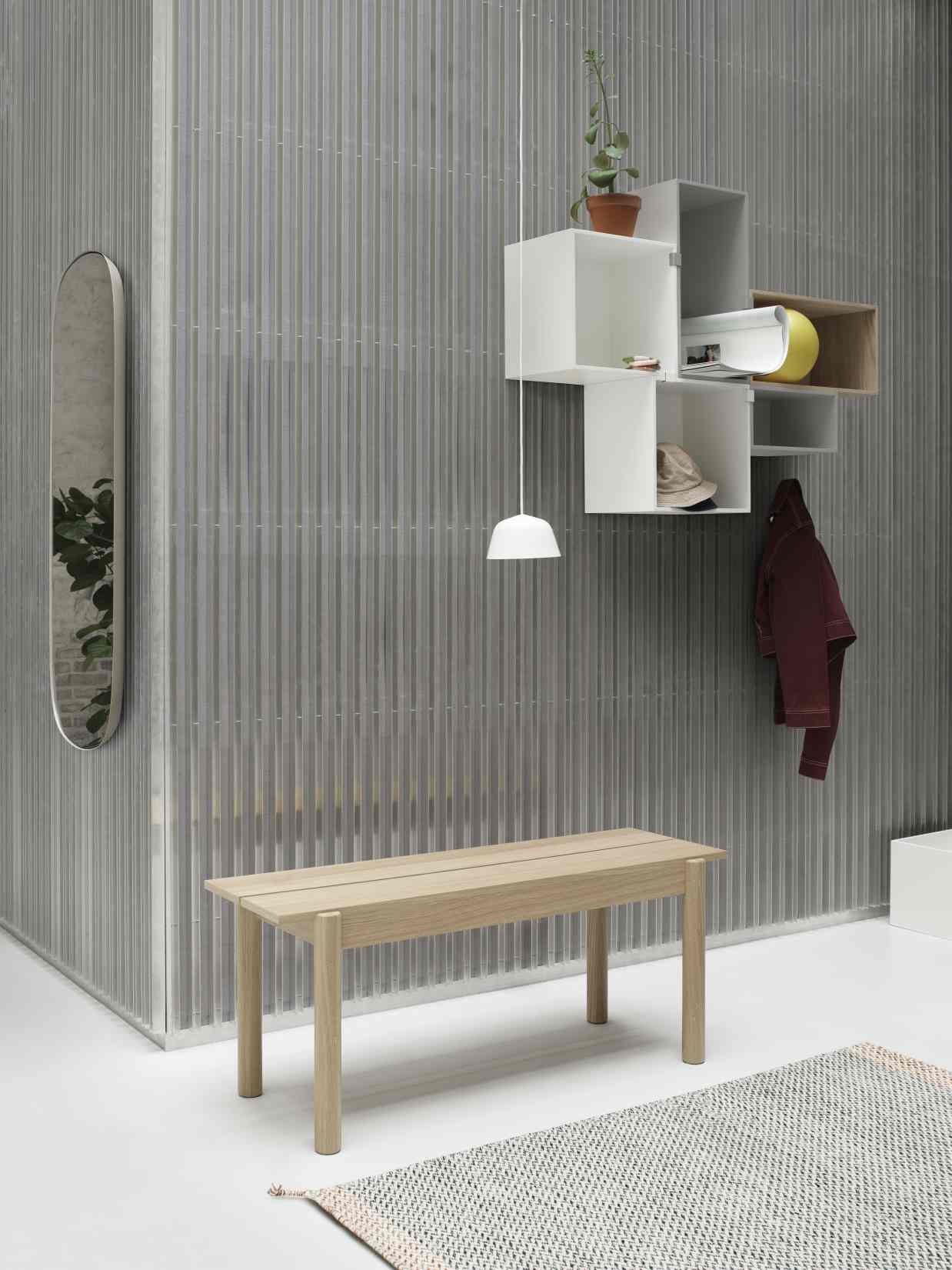 Modernes Interieur mit Muuto Stacked Storage System 2.0, Holzbank, Spiegel und minimalistischer Lampe für stilvolle Wohnraumgestaltung.