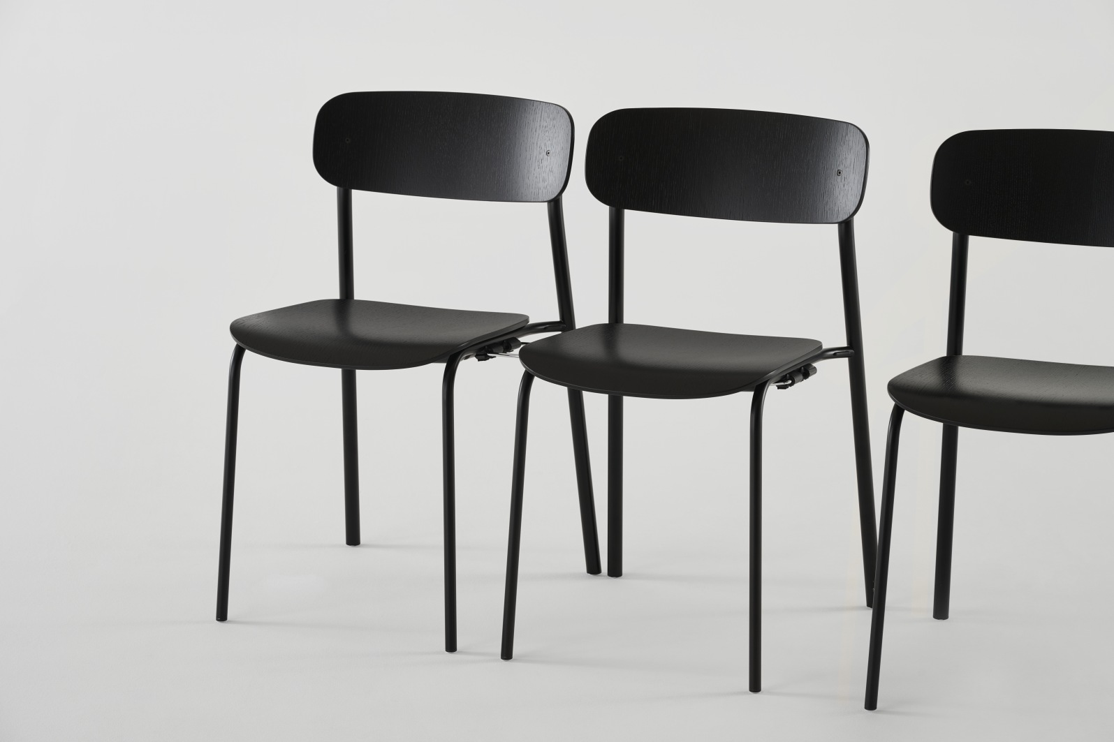 Drei schwarze S 243 Stahlrohrstühle von Thonet, minimalistisches Design mit Stahlrohrgestell und olivgrüner Sitzfläche.