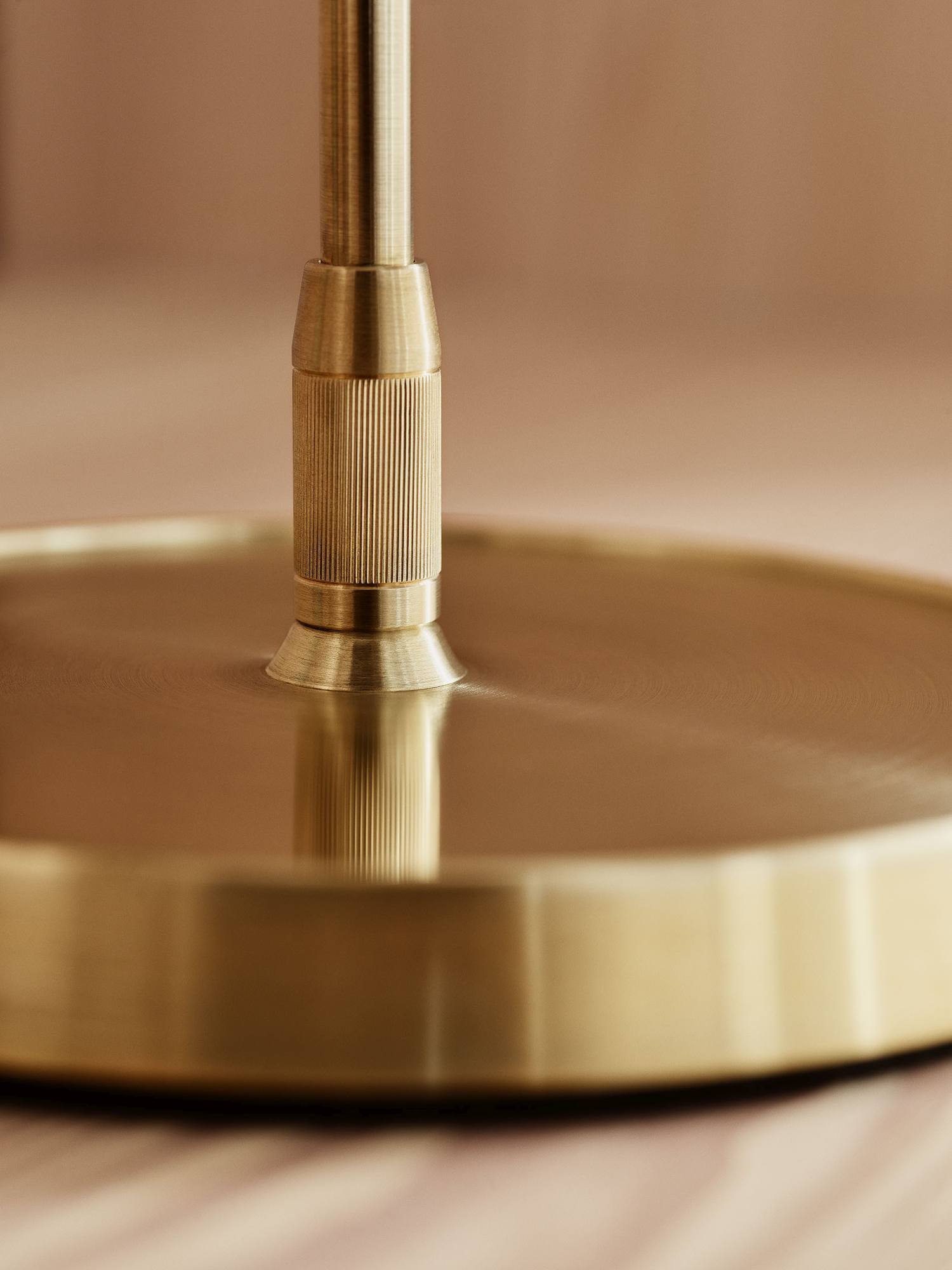 Detailaufnahme des goldenen Sockels der Clam Table Leuchte von Fritz Hansen.