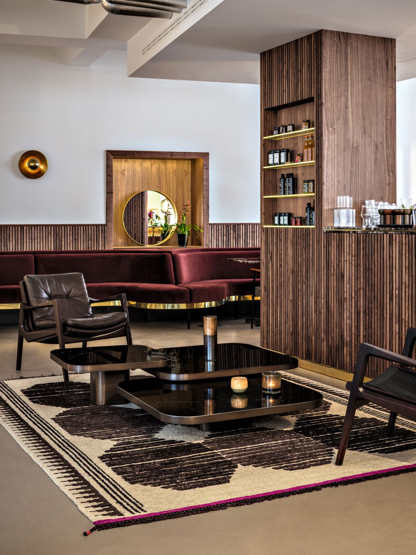 Elegantes Wohnzimmer Interieur mit braunem Ledersessel, Couch, Couchtisch und Teppich für stilvolles Wohnen.